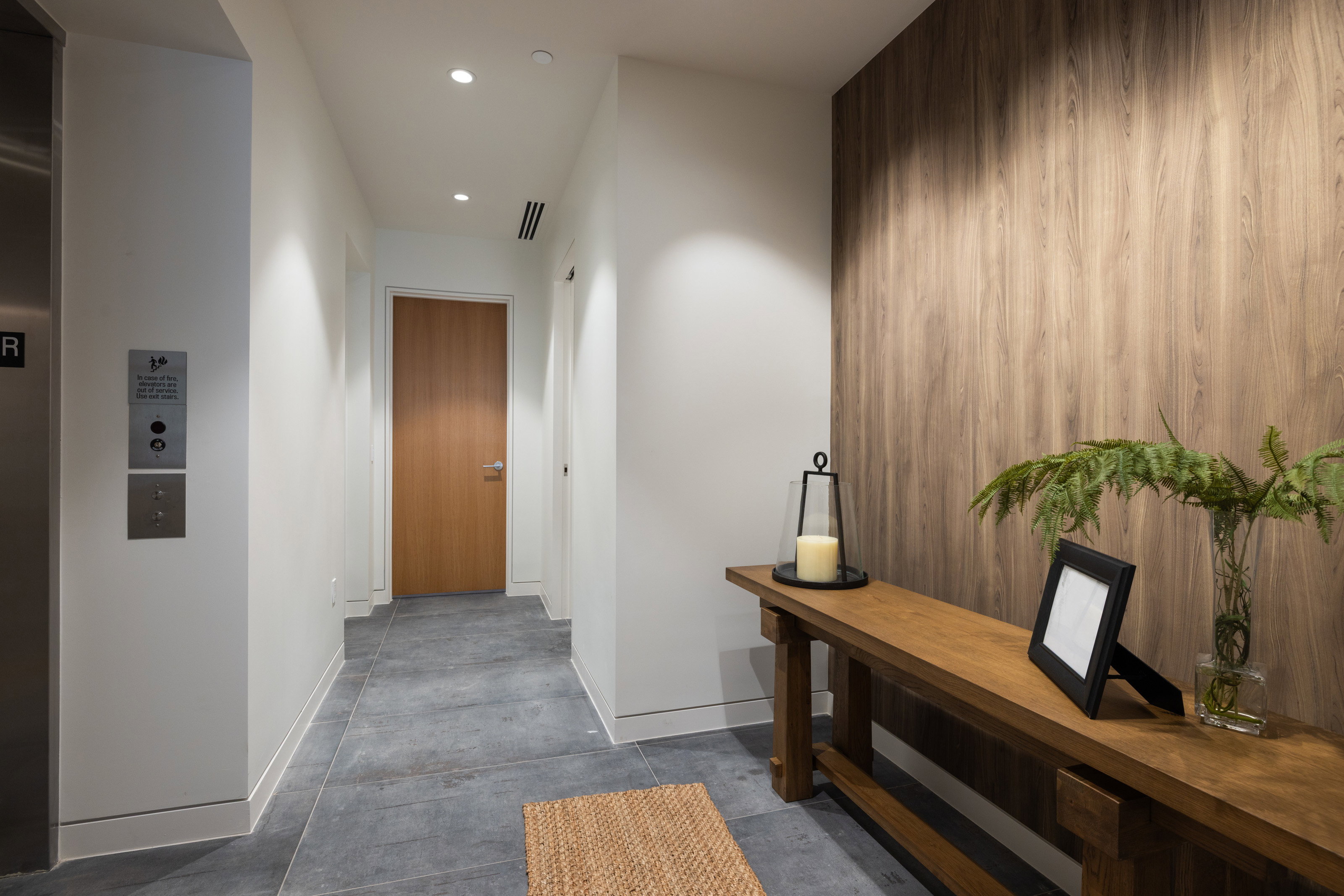 Entryway featuring a wood-panel accent wall, recessed lighting, and large format tile flooring