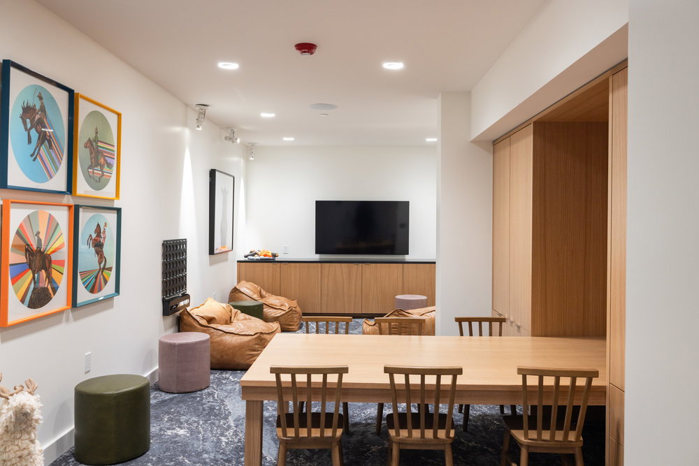 Spacious interior featuring dark stone-finish flooring, recessed lighting, and a light wood-finish built-in media console