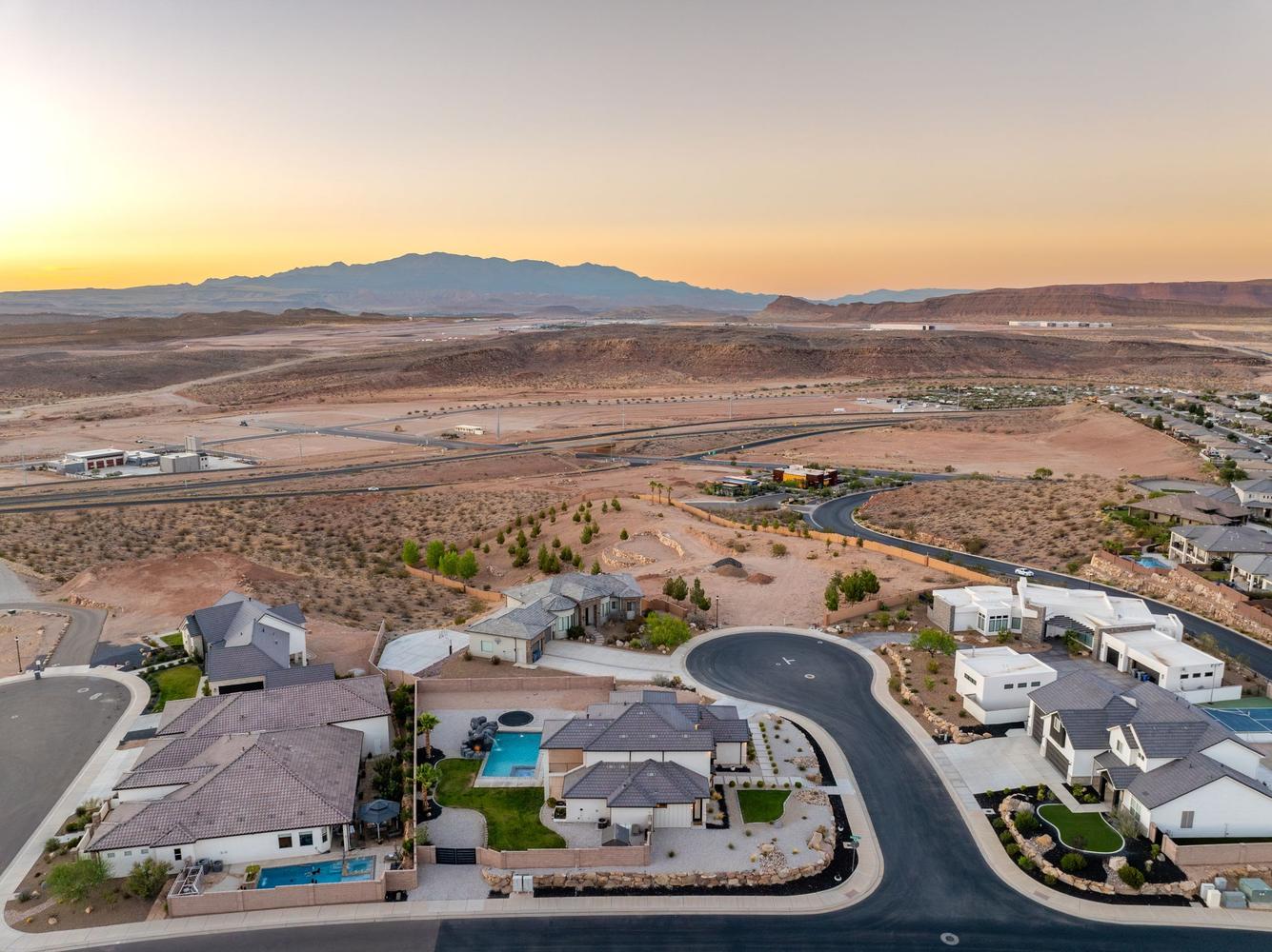 Aerial perspective showcasing a residential cul-de-sac with properties featuring private pools and structured landscaping