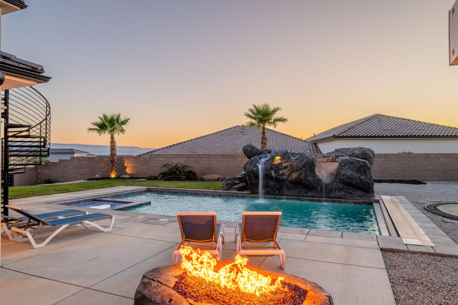 Backyard oasis featuring a swimming pool with rock waterfall feature, integrated spa, and concrete patio