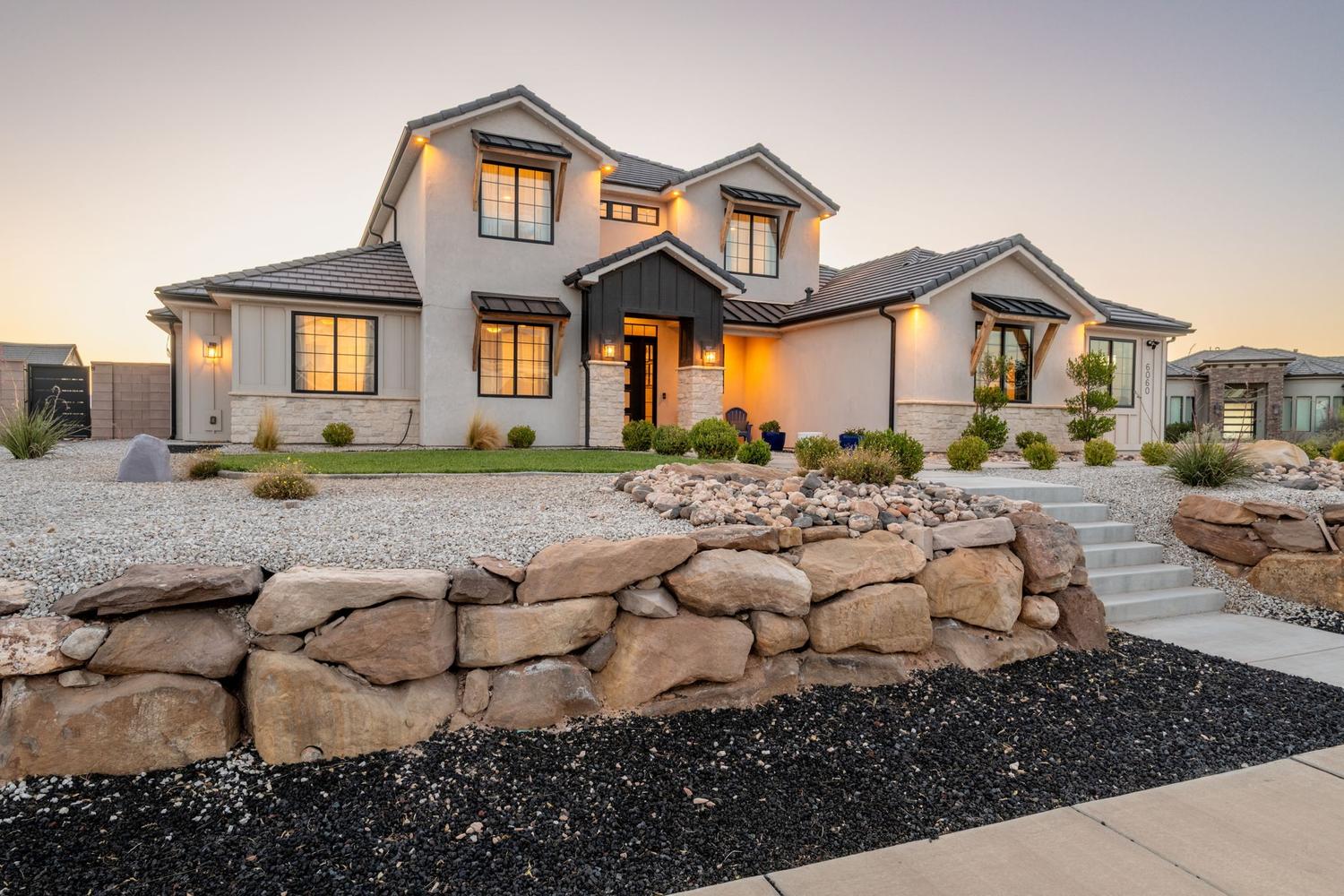 Contemporary two-story exterior featuring stucco and stone facade with dark trim accents