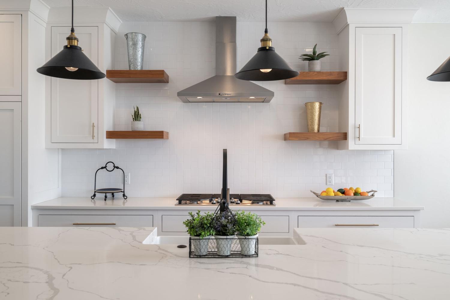 Modern kitchen featuring white shaker cabinetry, white subway tile backsplash, and light-toned countertops