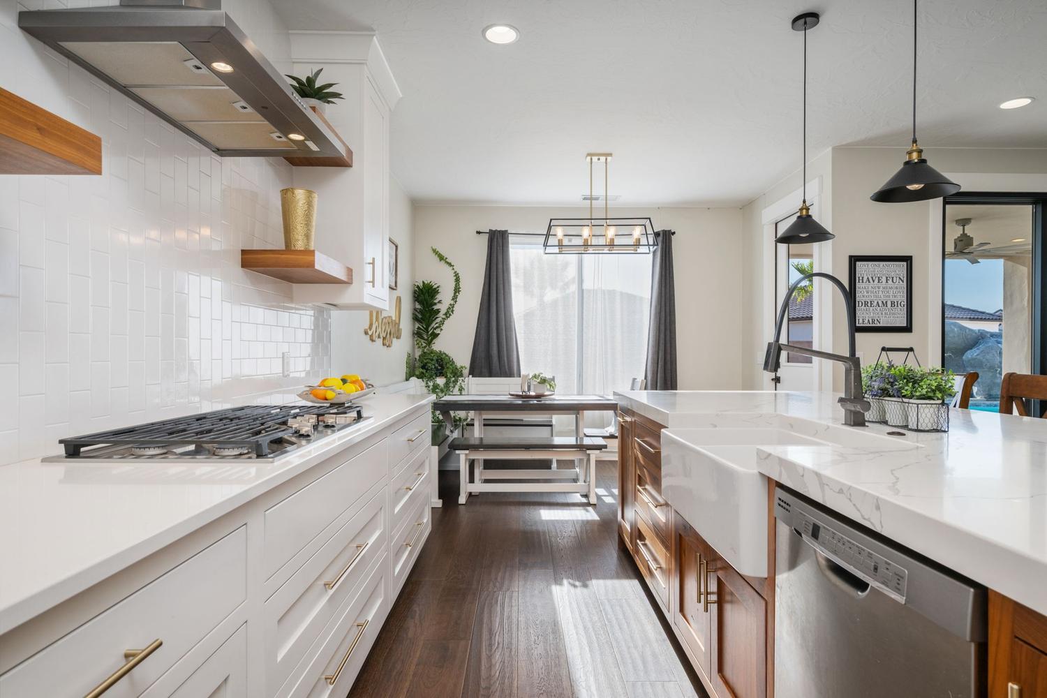 Gourmet kitchen featuring a gas cooktop, white subway tile backsplash, white shaker cabinetry, an apron-front sink, and stainless steel appliances