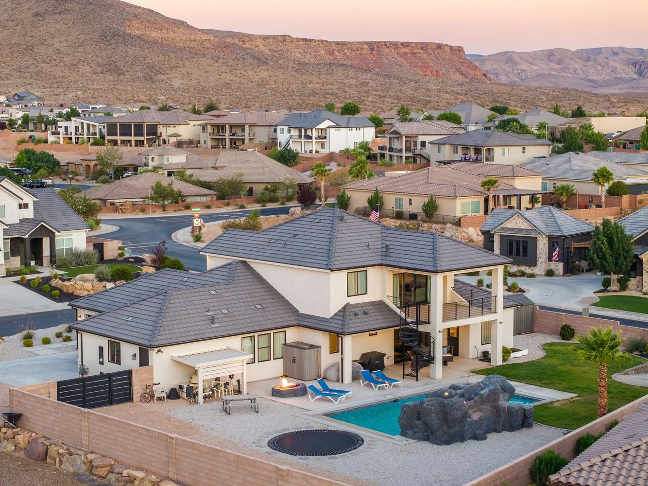Contemporary multi-story residence featuring a private pool with rock features and a trampoline