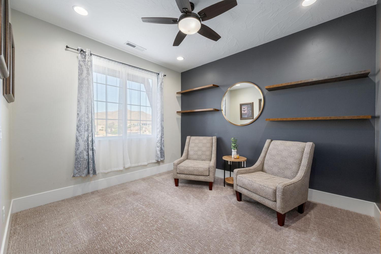 Room featuring recessed lighting, a ceiling fan, a window with exterior mountain scenery, and built-in wood-finish shelving