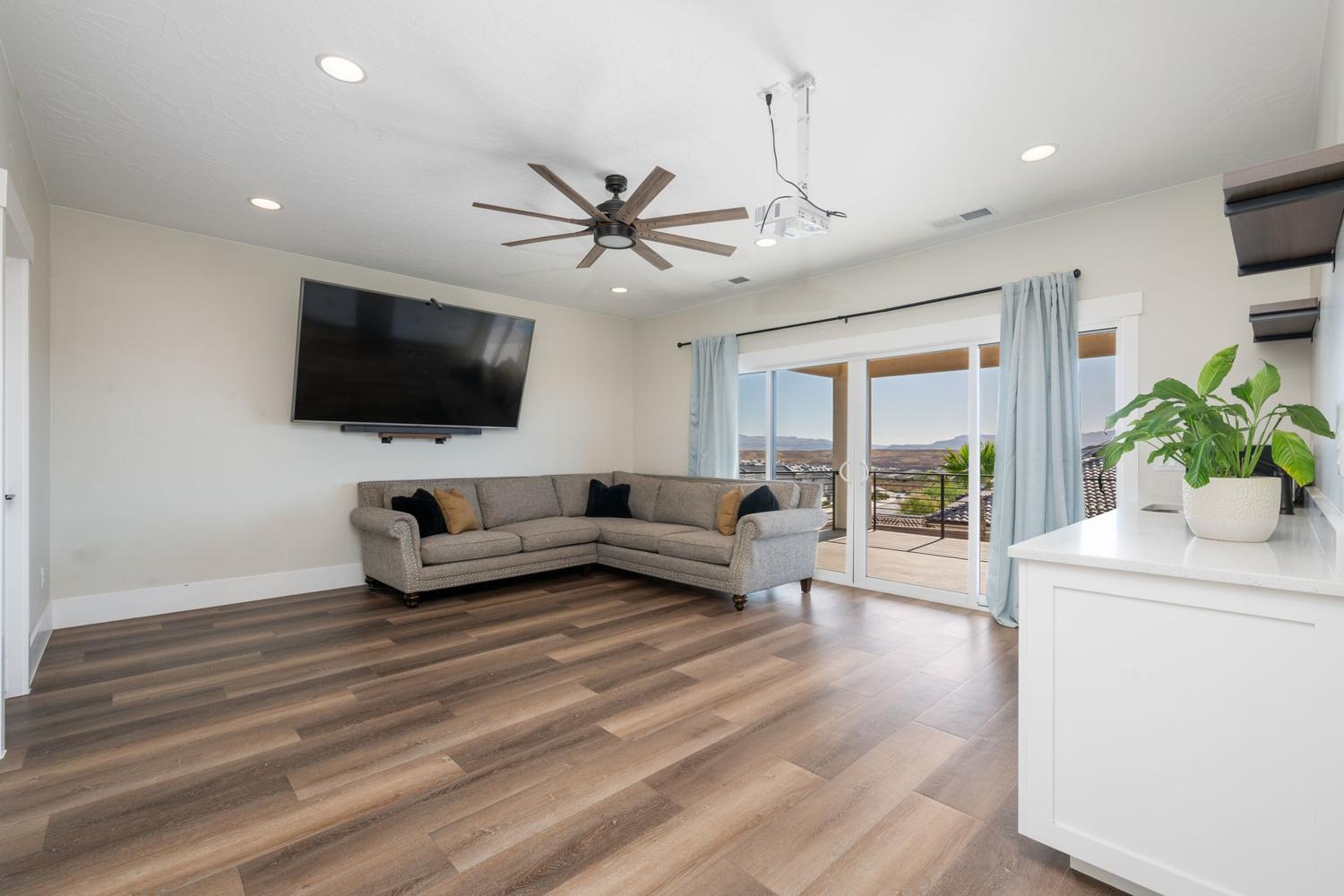Spacious room featuring wood-finish flooring, recessed lighting, and a ceiling fan