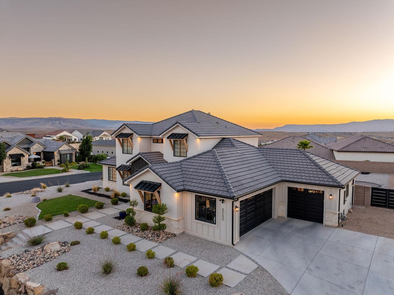 Contemporary architecture featuring a white stucco exterior with dark trim and a tiled roof
