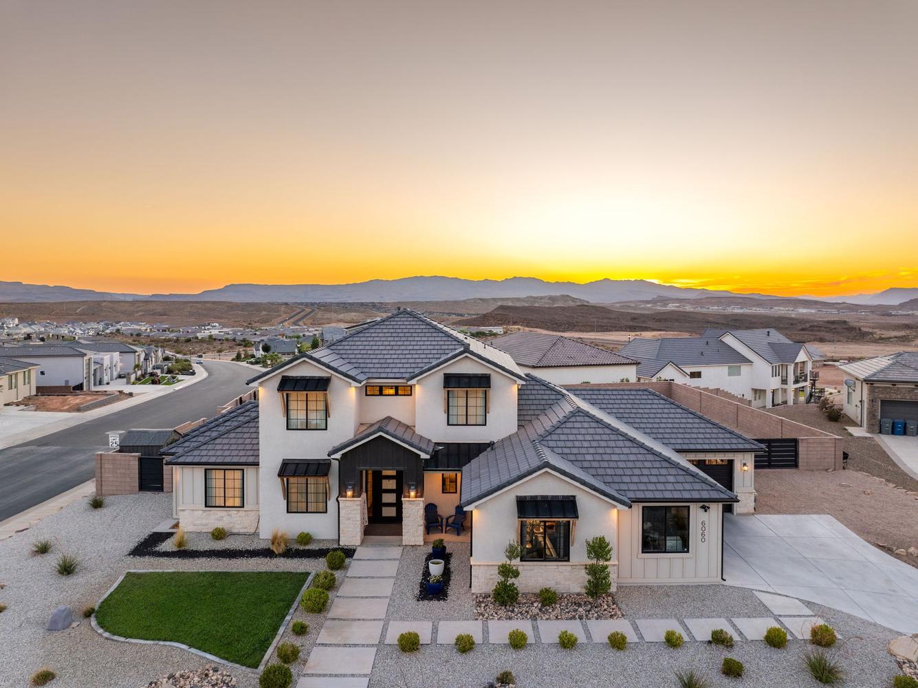Contemporary home featuring a light-colored exterior with dark trim and a multi-gabled roof