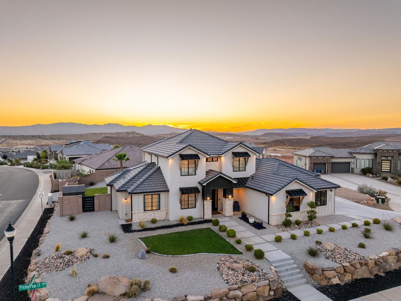 Contemporary two-story residence featuring a white stucco exterior with black trim accents and a dark tile roof