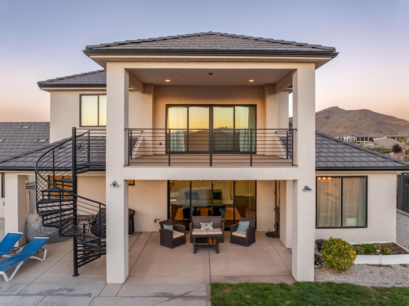The rear exterior features a multi-level design with a covered patio and an upper-level balcony