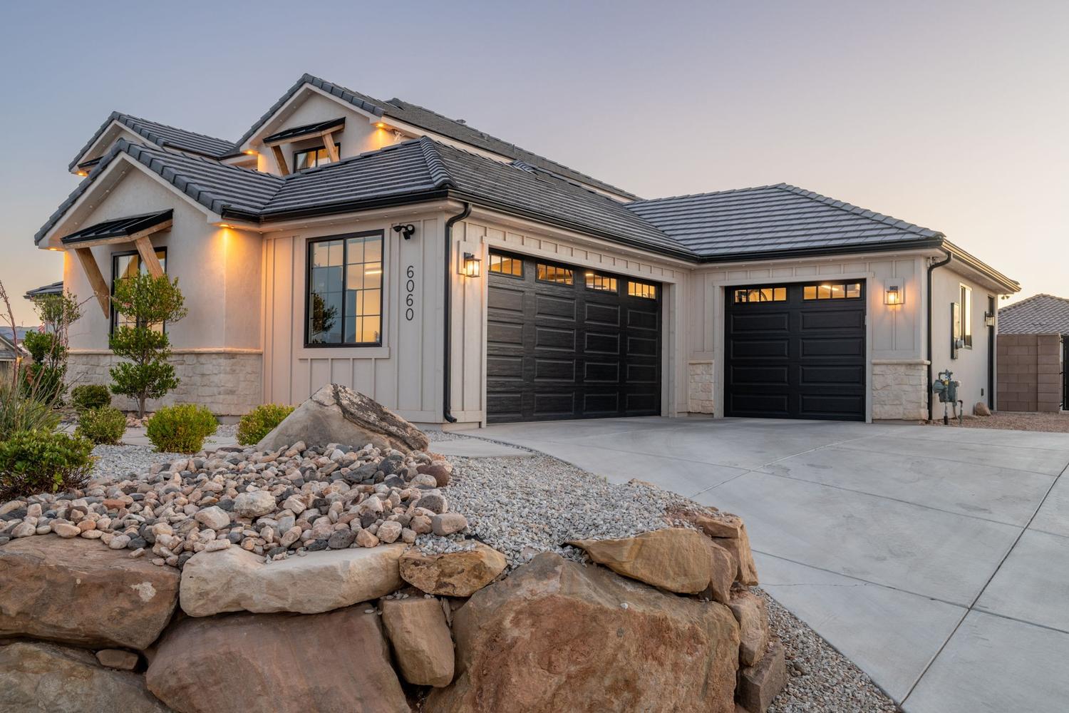 Modern farmhouse exterior featuring board and batten siding, stone accents, and a dark tile roof