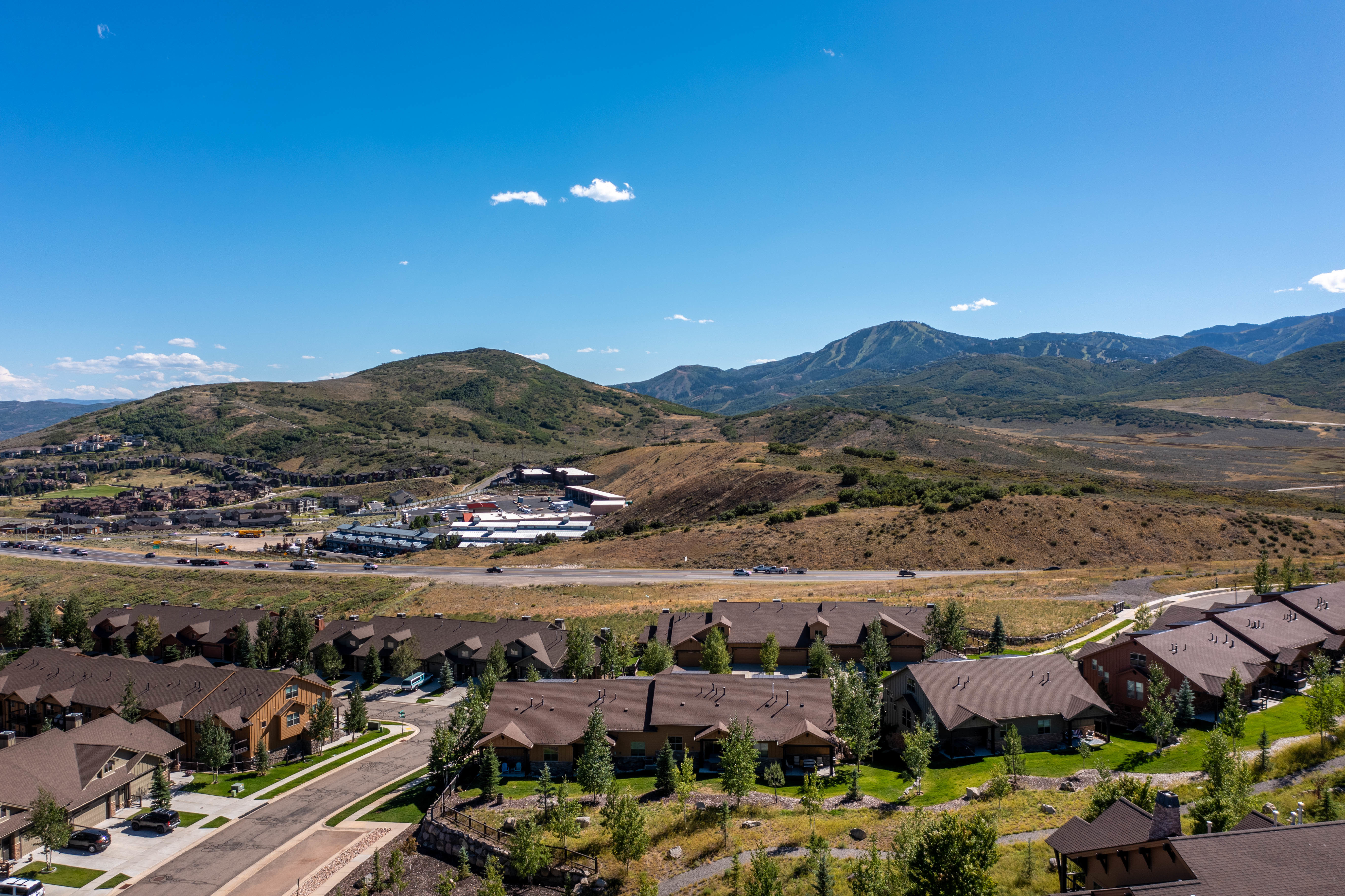 Aerial perspective showcasing residential properties with mountain backdrops and a clear sky