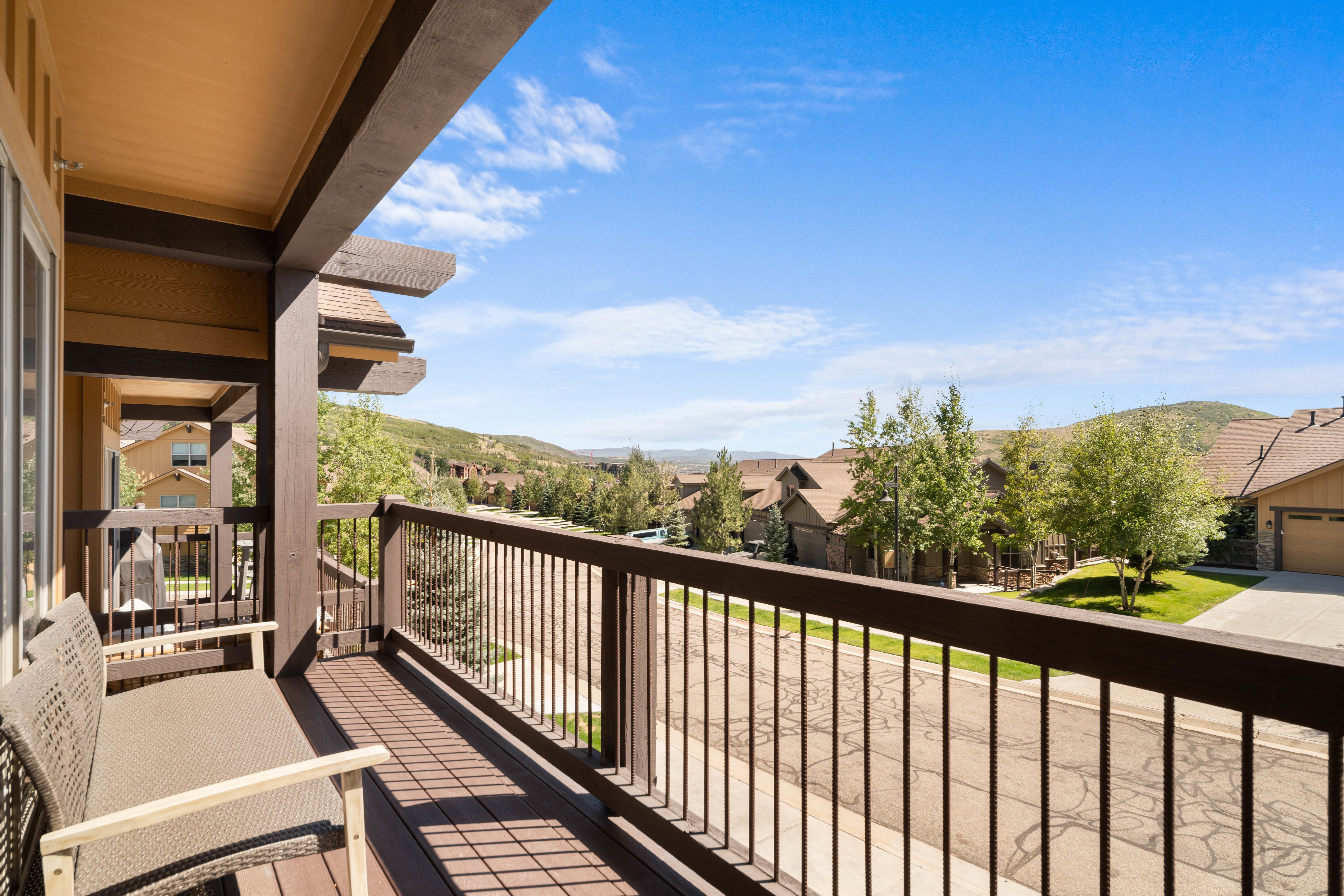 Expansive outdoor deck featuring wood-finish flooring and dark-toned railings