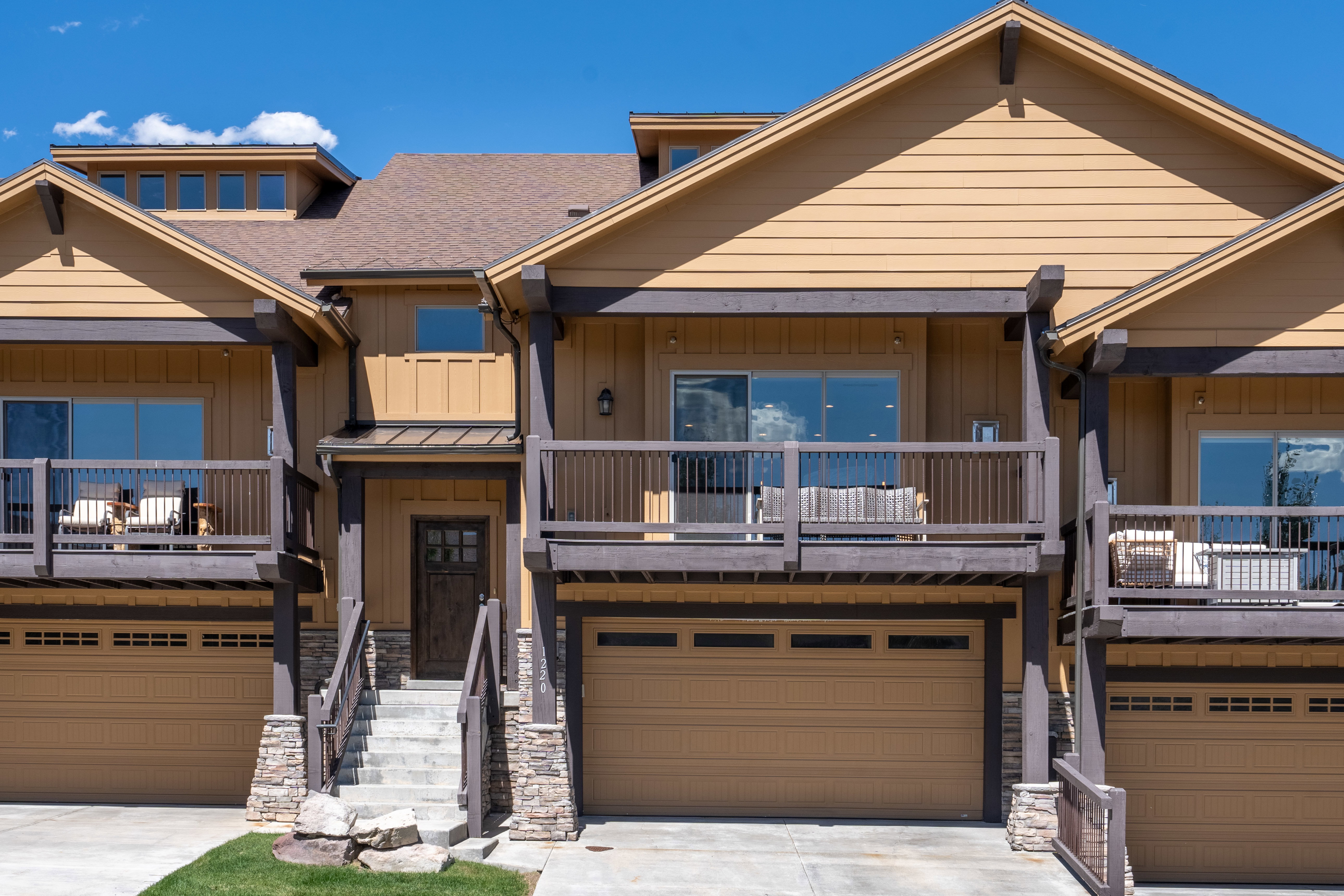 Multi-level dwelling with a light brown siding and dark brown trim