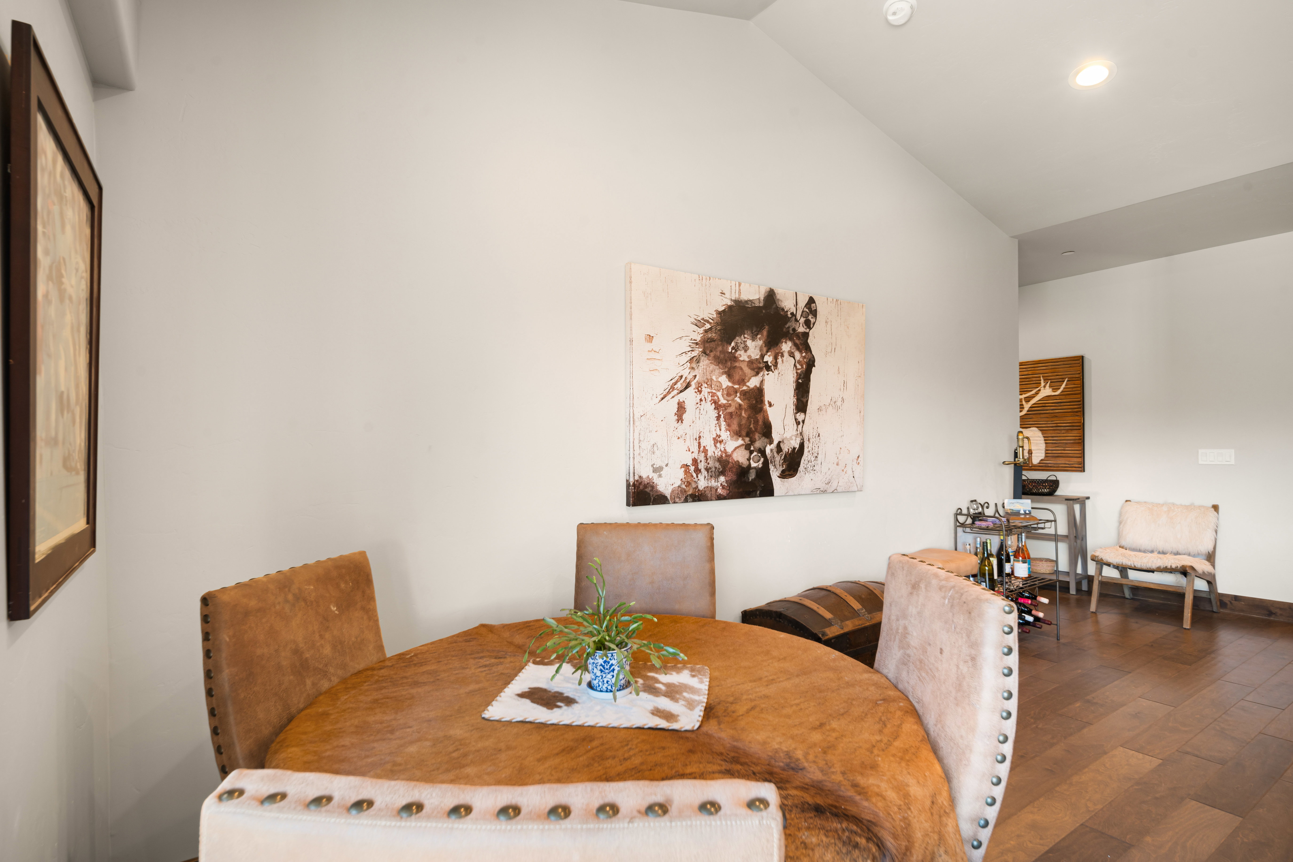 Vaulted ceilings enhance this open space featuring wood-finish flooring and recessed lighting