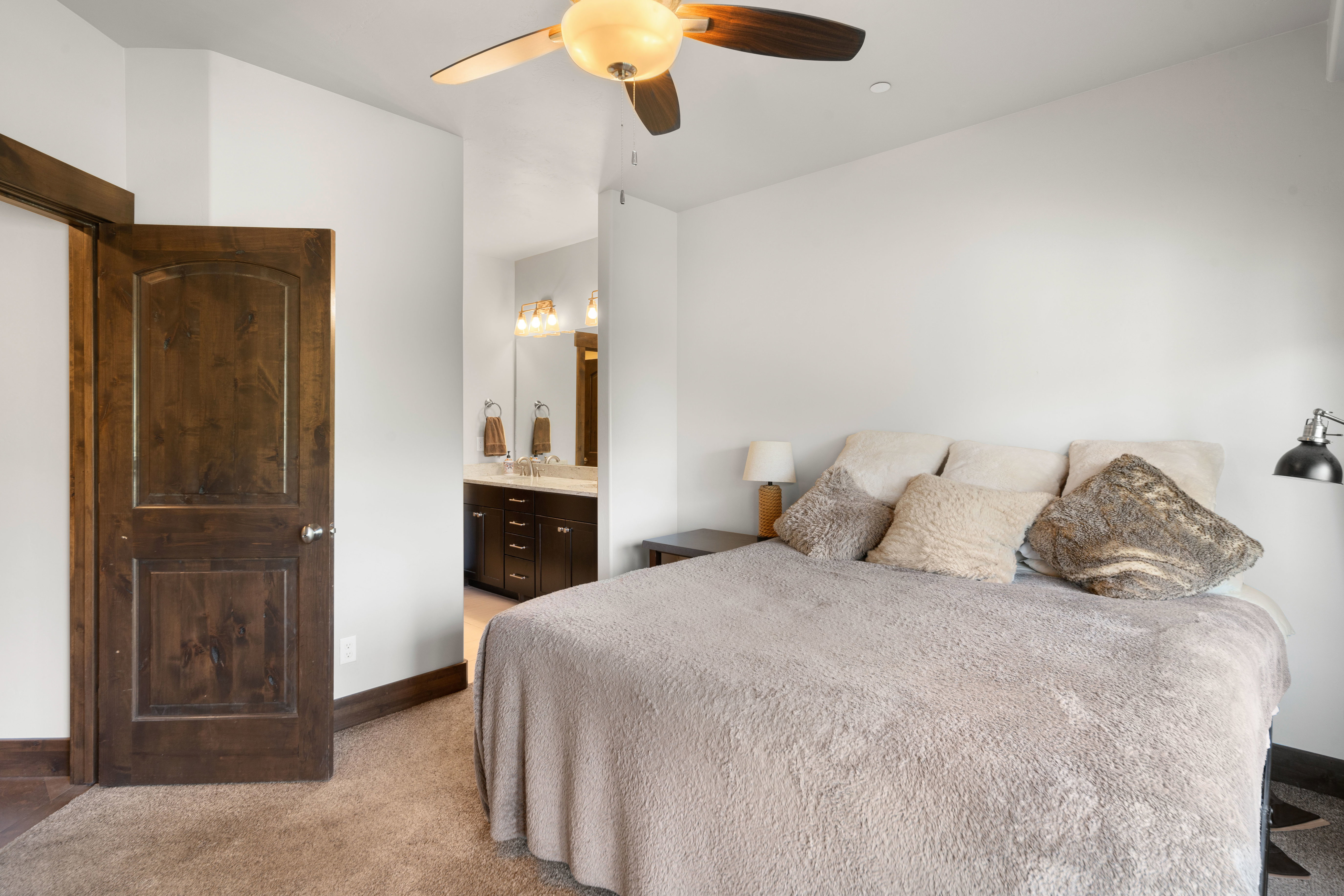 Bedroom featuring a ceiling fan with integrated lighting, wood-finish interior doors, and carpet flooring