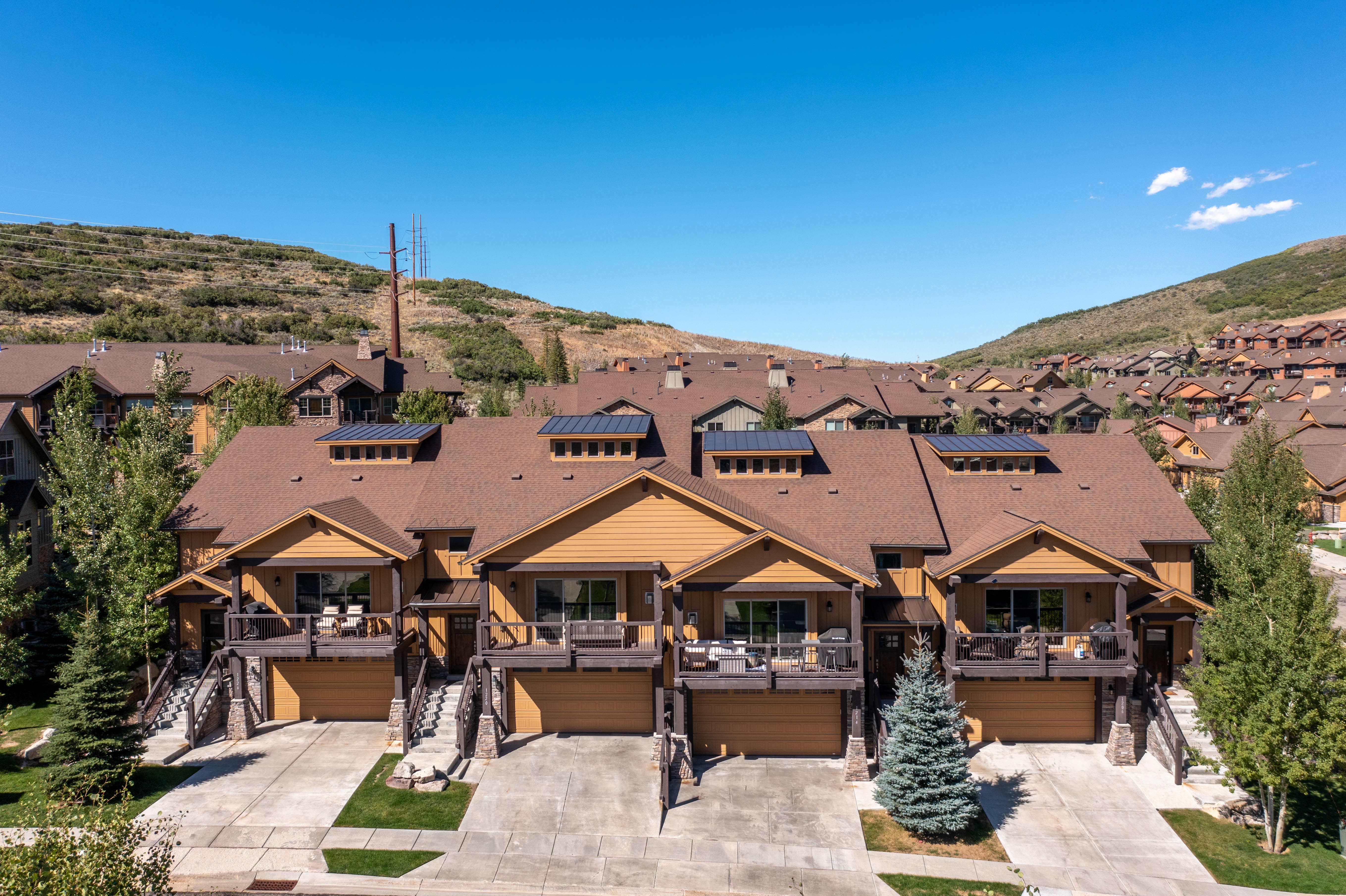 Multi-level residences featuring warm-toned siding and dark brown roofing
