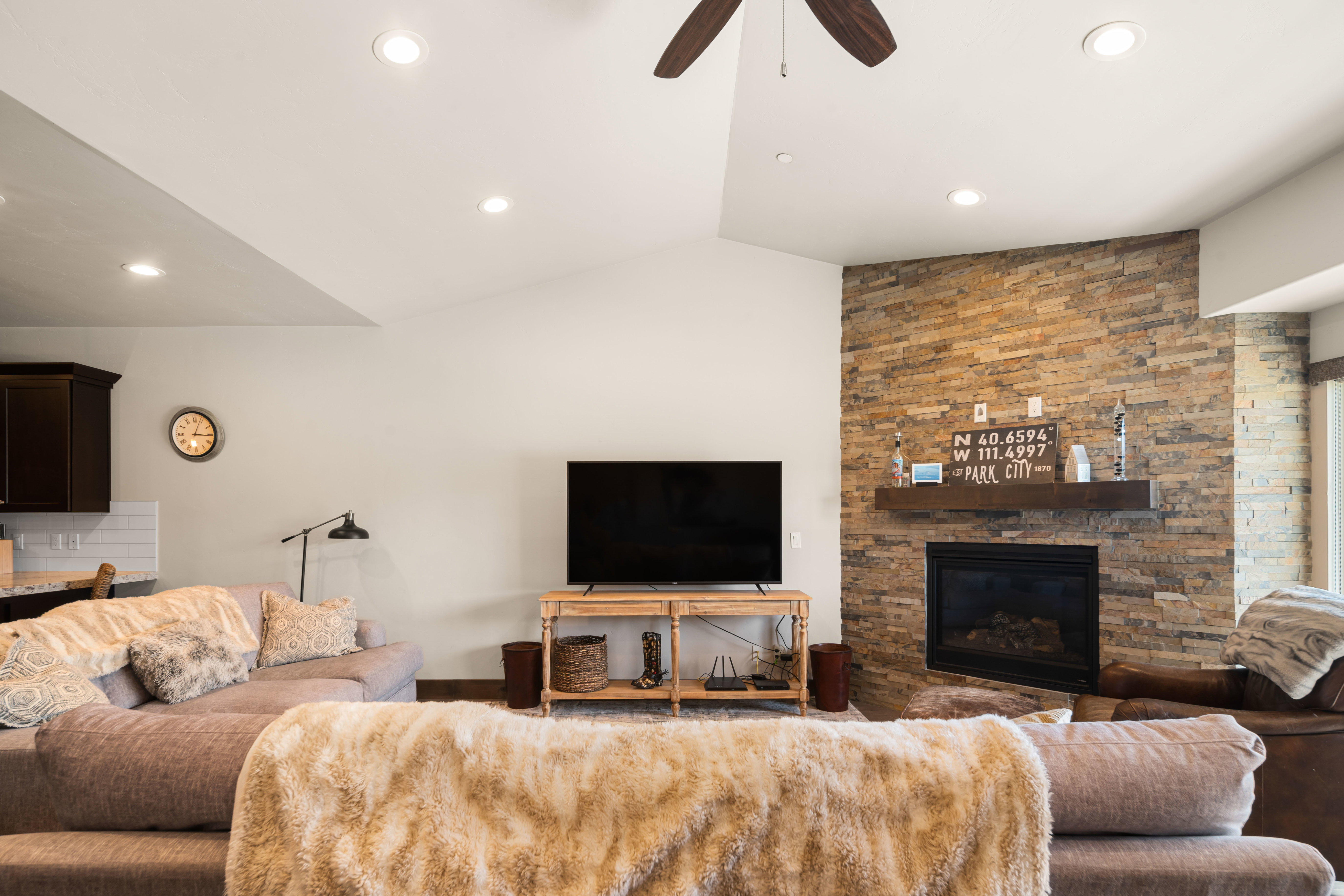 Living area featuring a stone accent wall with an integrated fireplace and a dark wood mantel