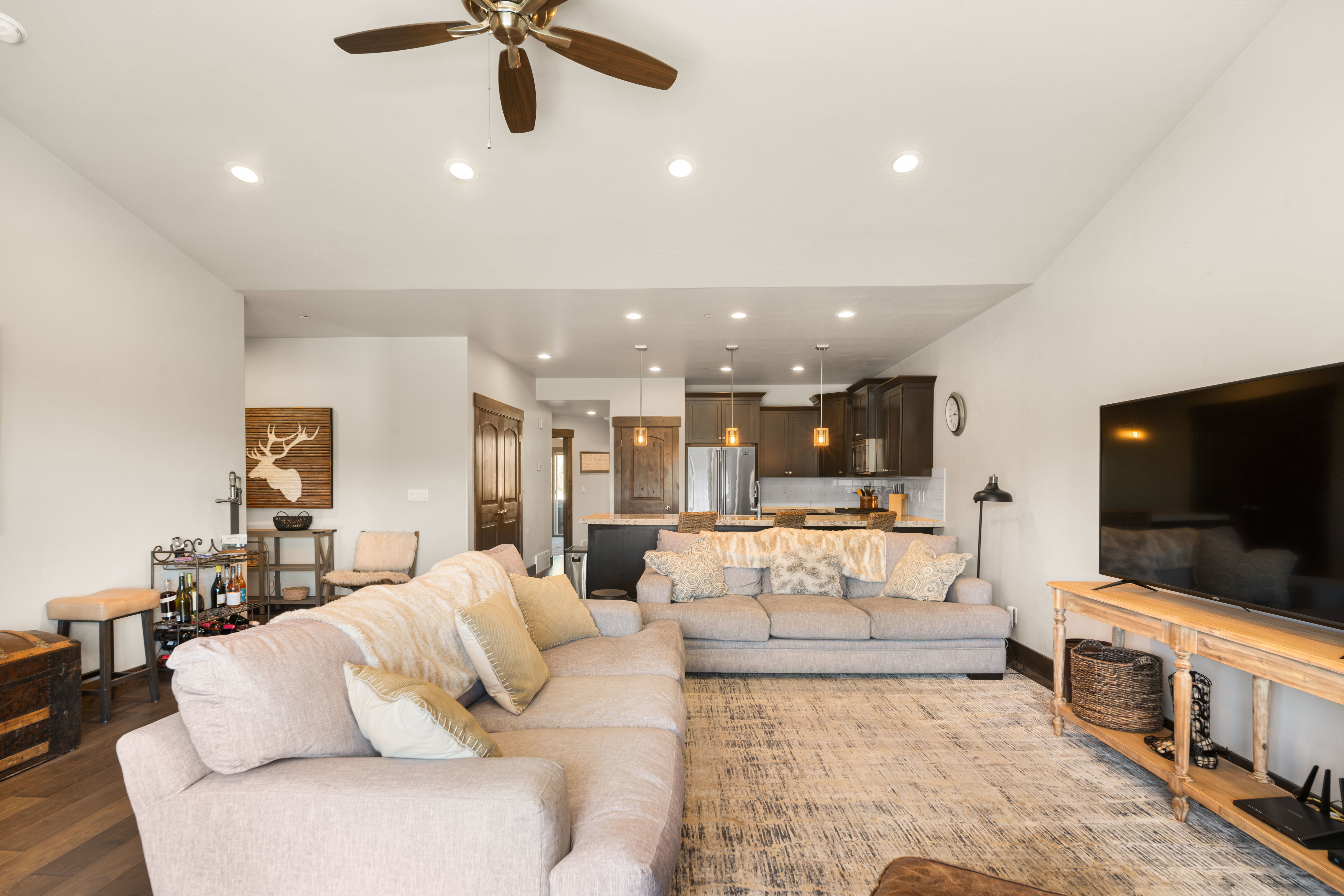 Spacious living area featuring wood-finish flooring, recessed lighting, and a ceiling fan