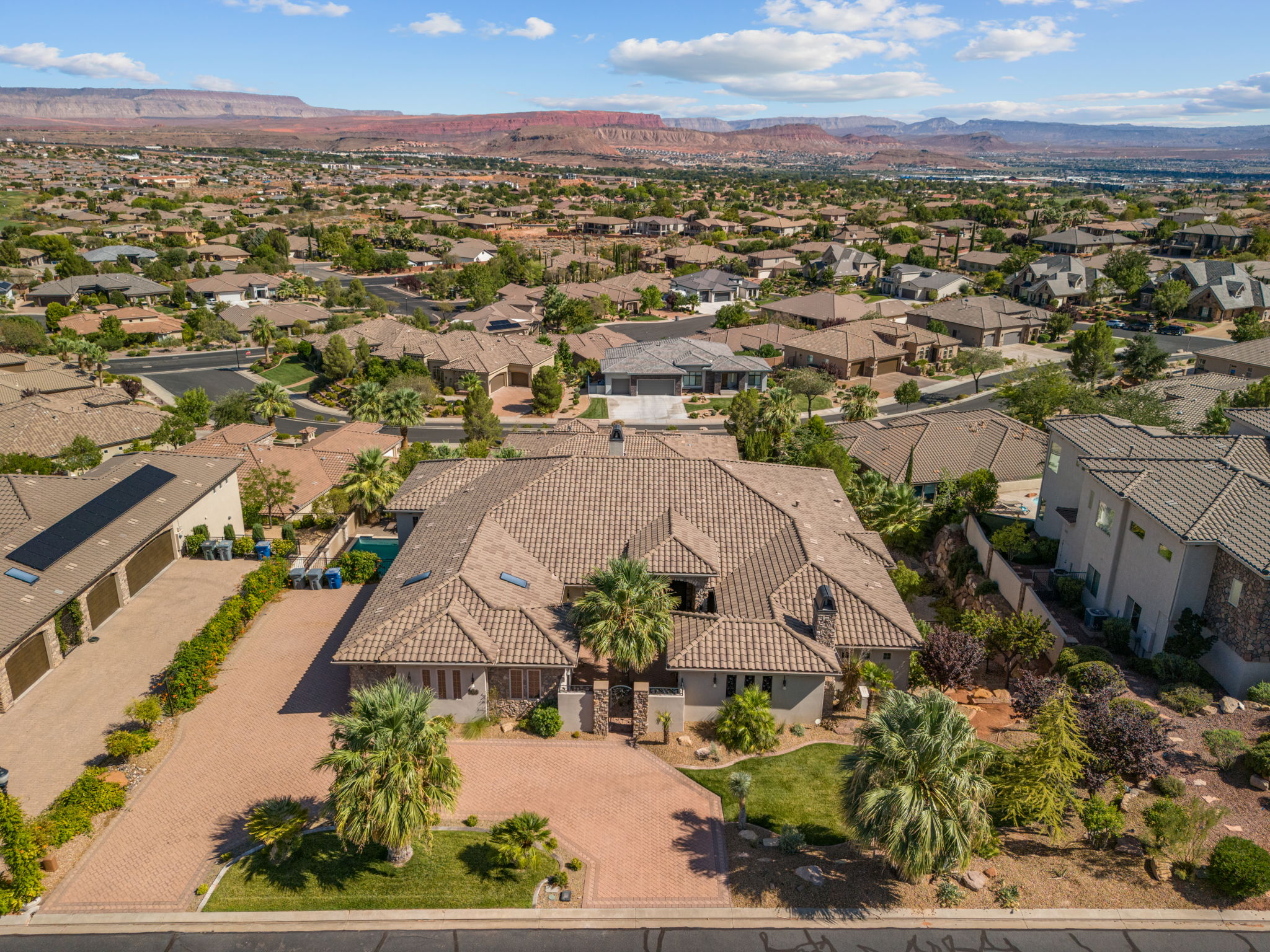 Expansive property with a tile roof and a paver driveway