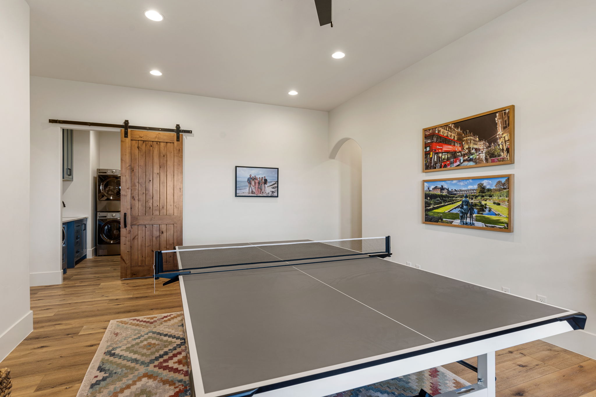 Spacious room featuring wood-finish flooring and recessed lighting