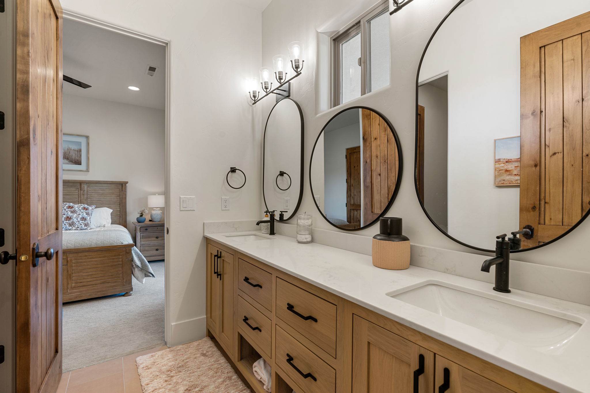 Double vanity featuring light wood-finish cabinetry, white countertops, and integrated rectangular sinks