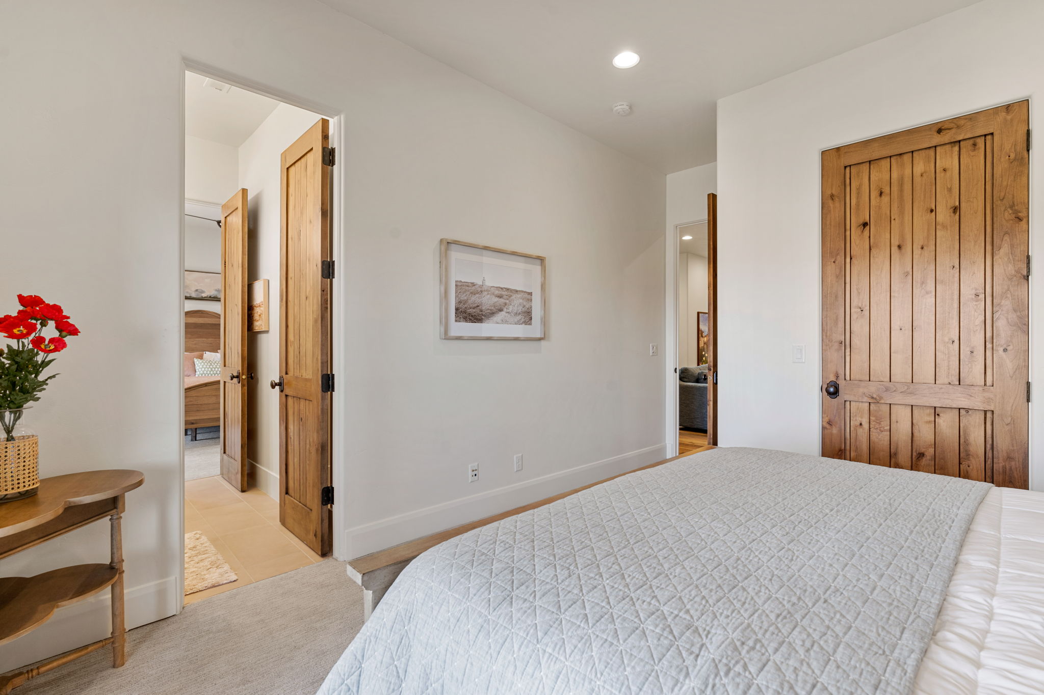 Interior space featuring light-colored walls, recessed lighting, and wood-finish panel doors with dark hardware