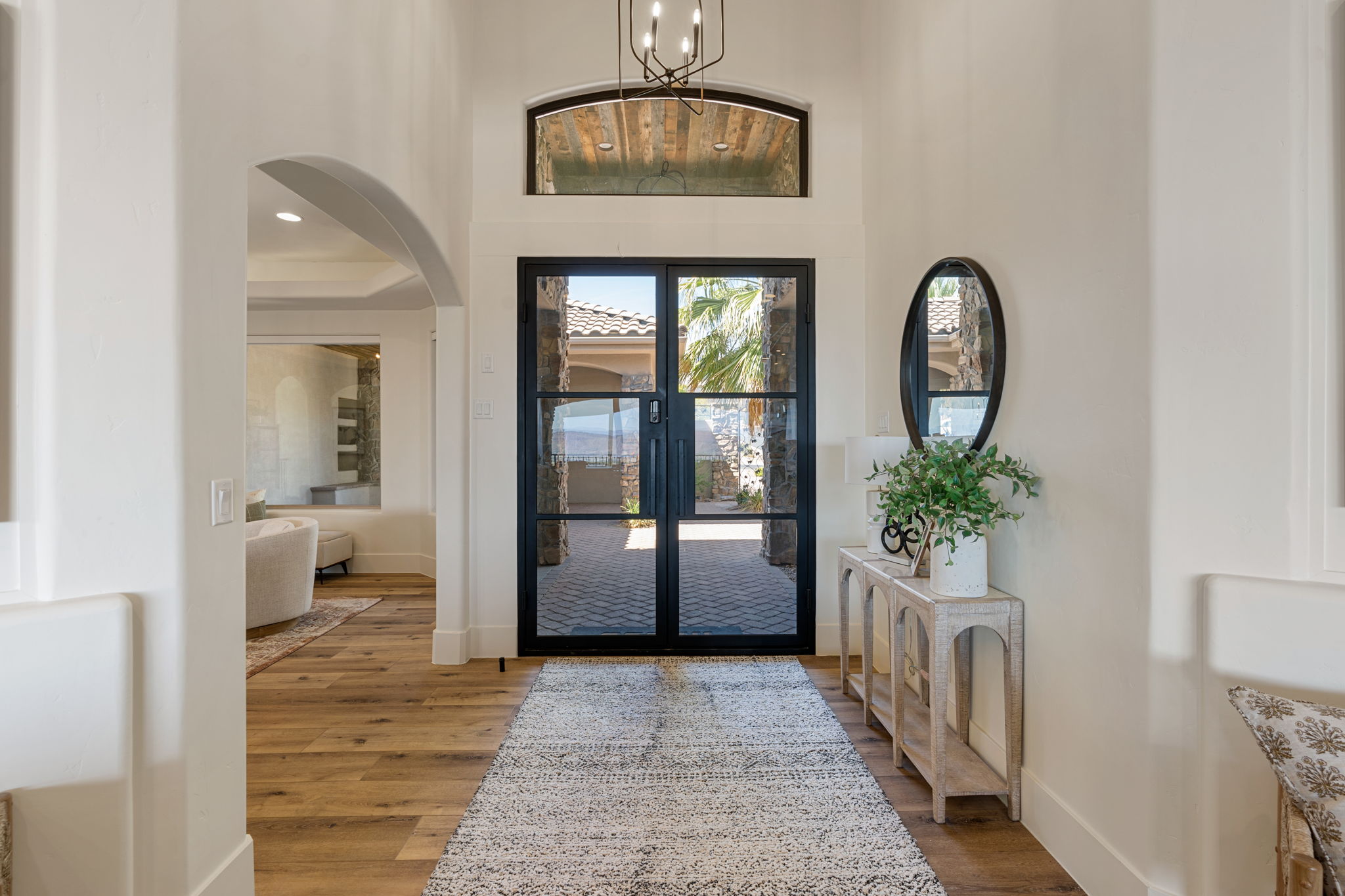 Entryway featuring black-framed double glass doors, a transom window, and wood-finish flooring