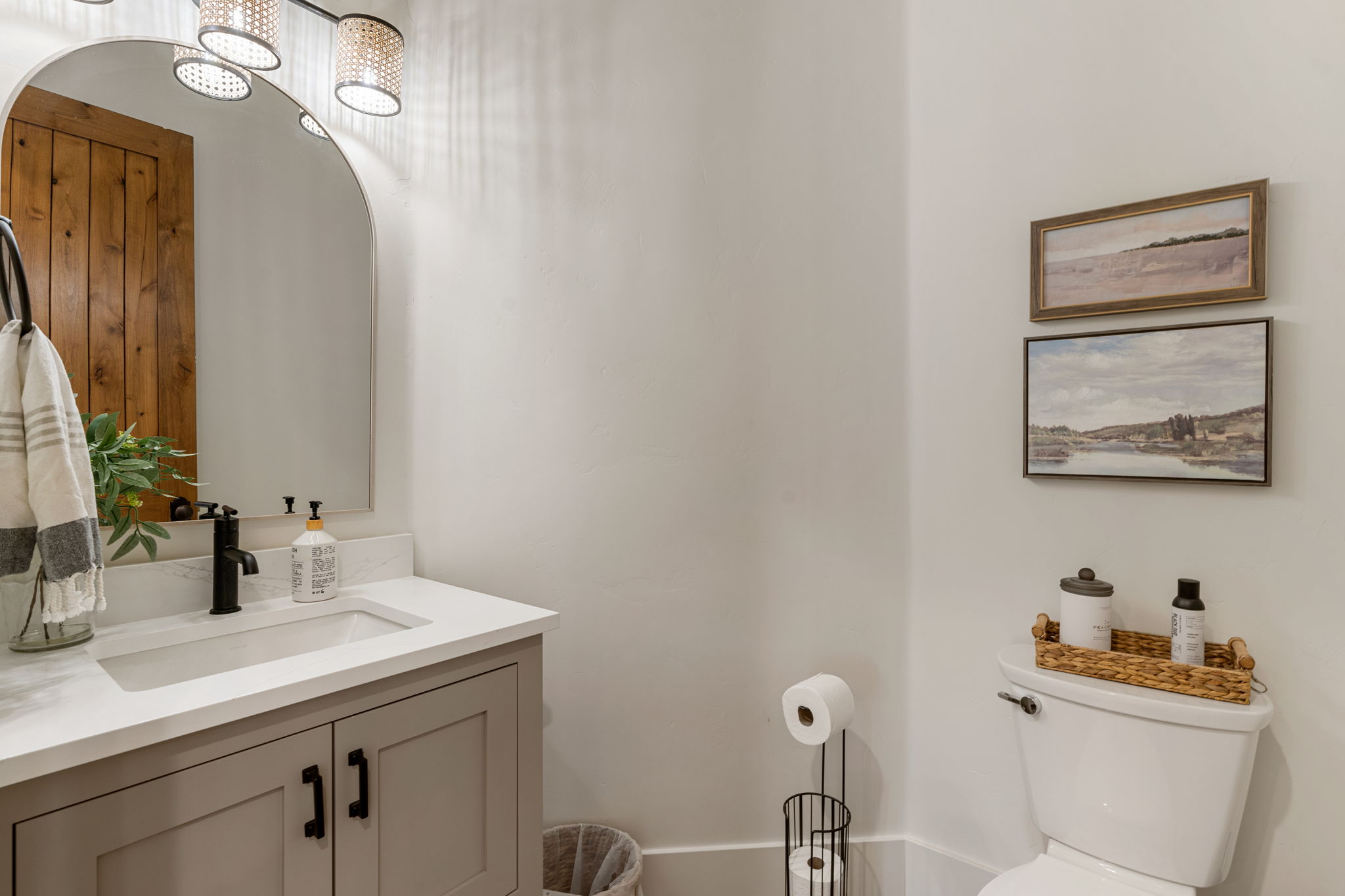 Bathroom featuring a white countertop with an undermount sink, a dark finished faucet, and cabinetry with dark hardware