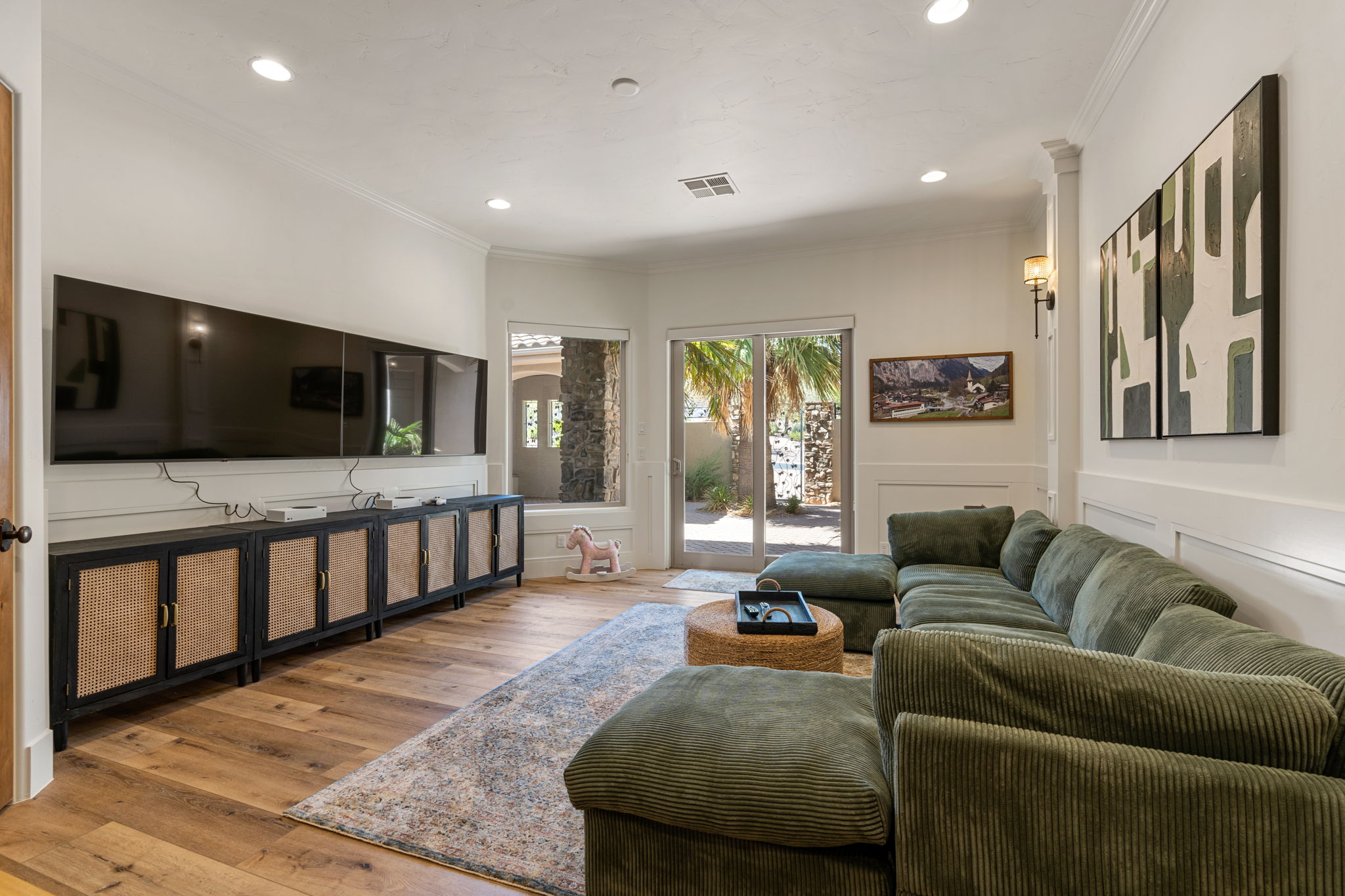 Spacious living area featuring wood-finish flooring, recessed lighting, and a built-in media console