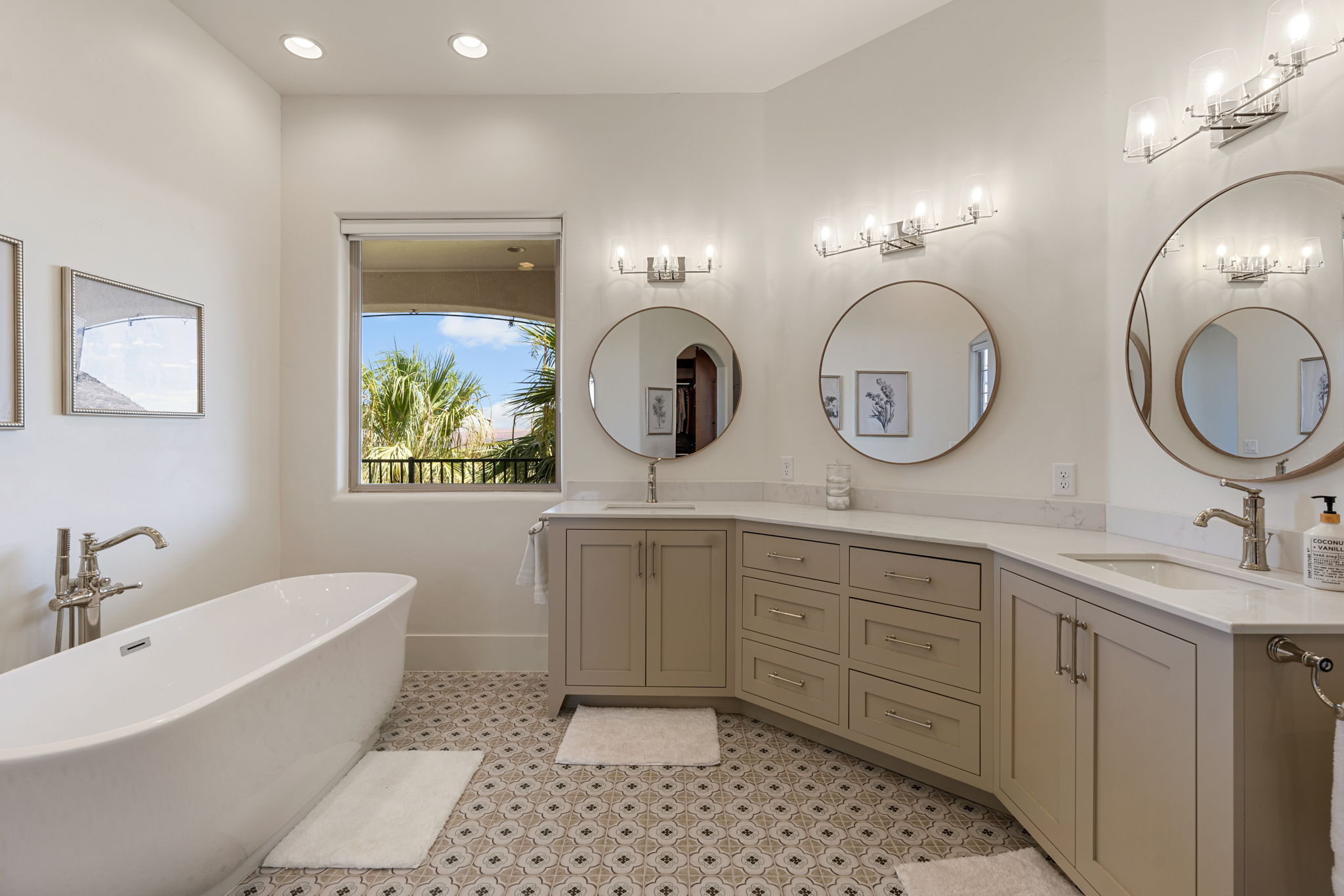 Freestanding soaking tub complemented by a double vanity with integrated sinks, quartz countertops, and brushed nickel fixtures