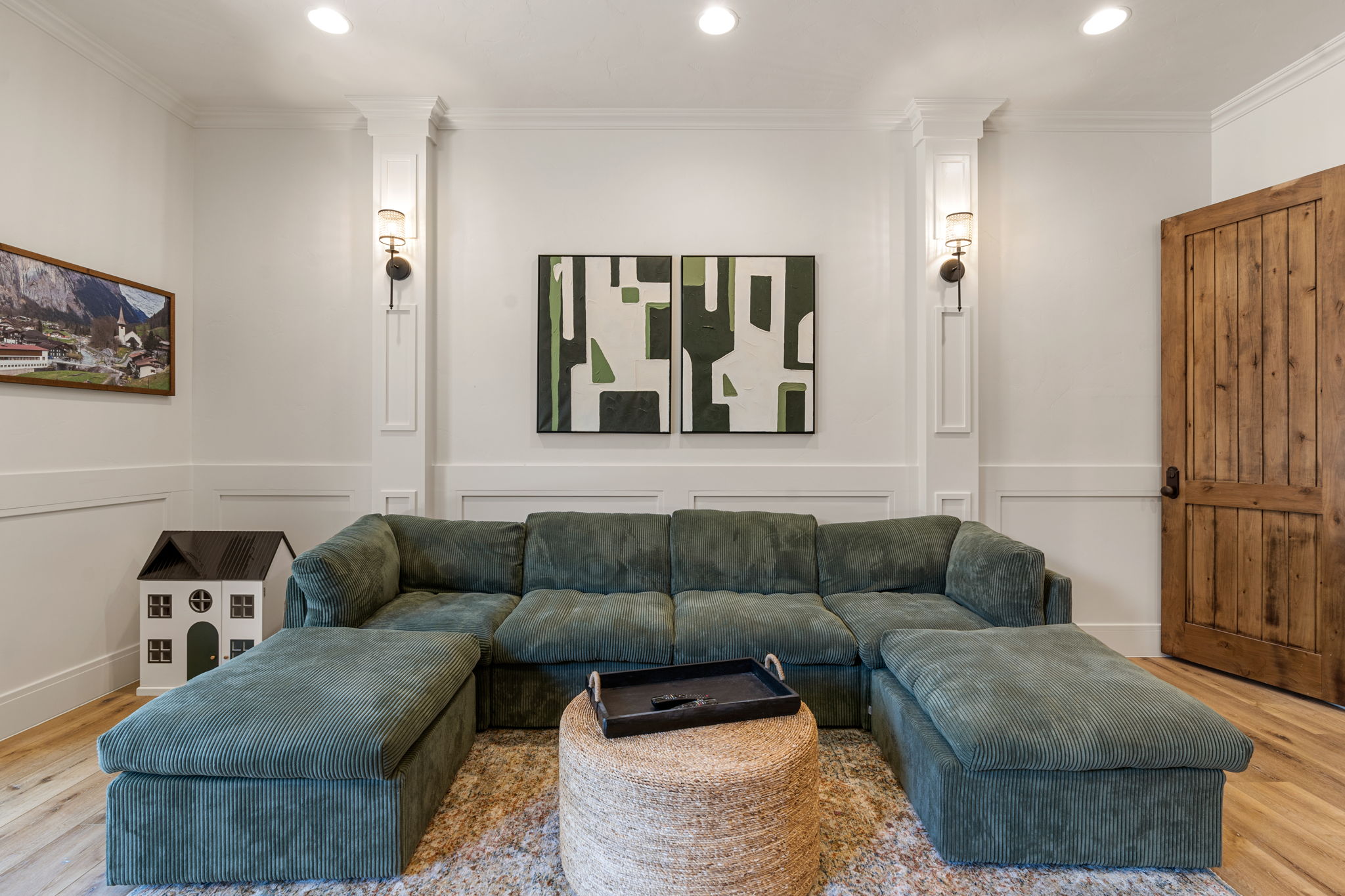 White paneled walls with sconce lighting and recessed ceiling lights