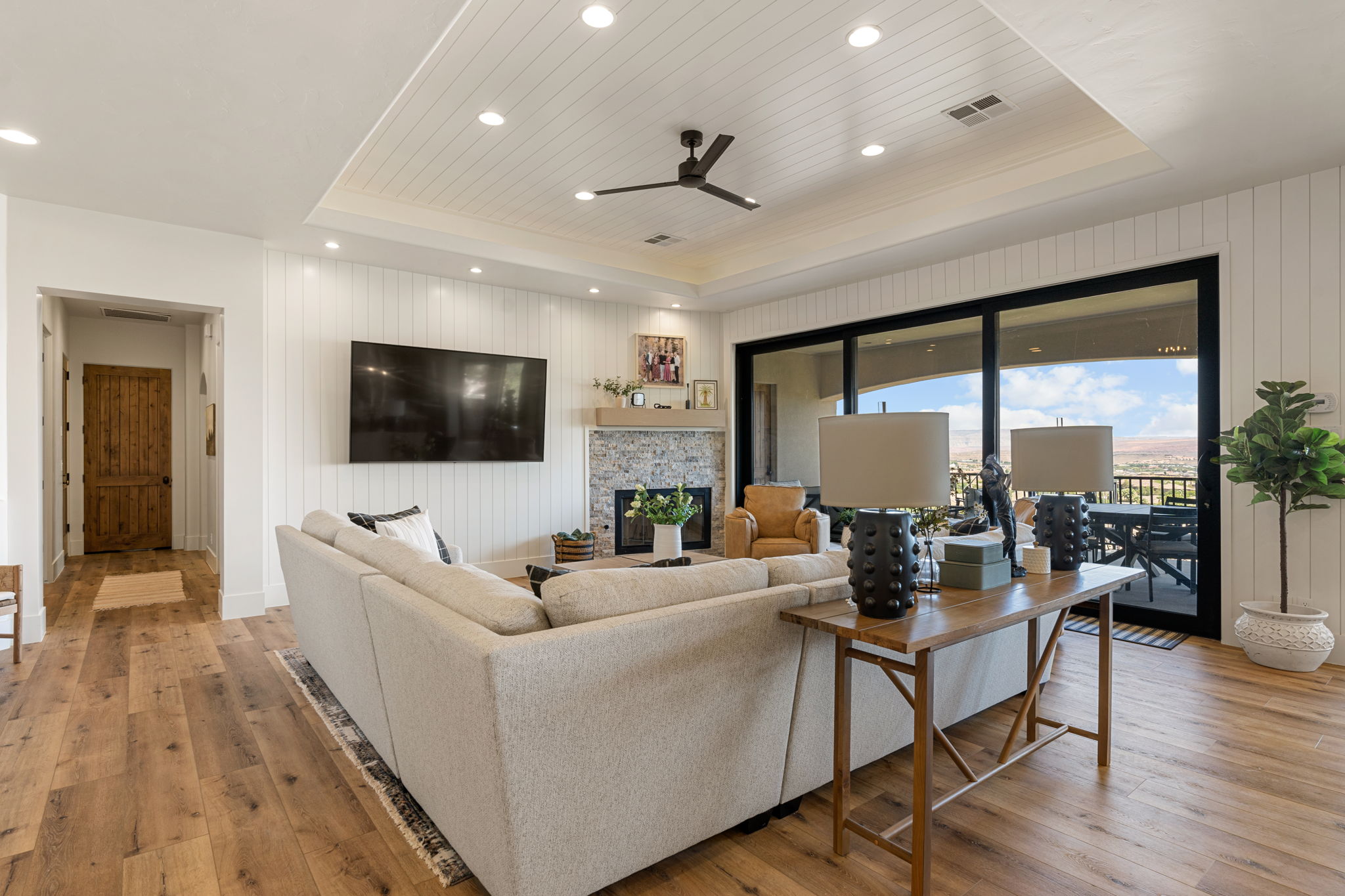 Living area featuring wood-finish flooring, white shiplap walls, and a recessed shiplap ceiling with integrated lighting