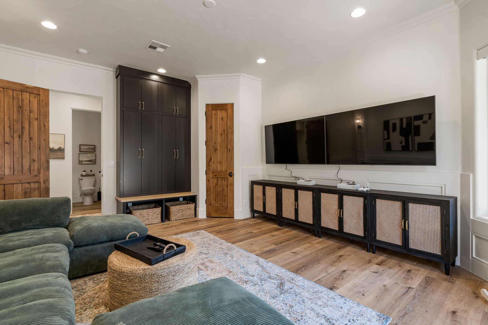 Spacious living area featuring light wood-finish flooring, recessed lighting, and white crown molding