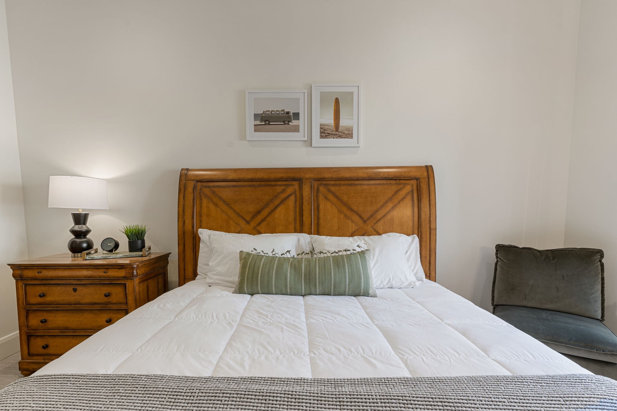 Light-toned wall finishes complement a wood-finish headboard with panel detailing