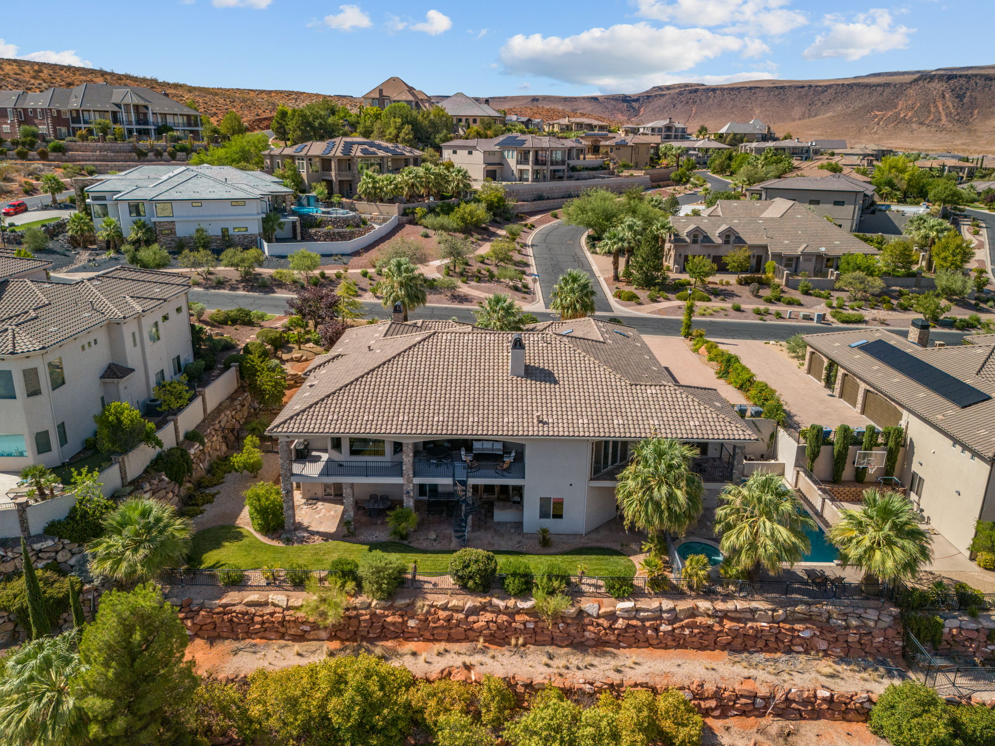 Expansive hillside residence featuring a multi-level patio, private swimming pool, and detached garages