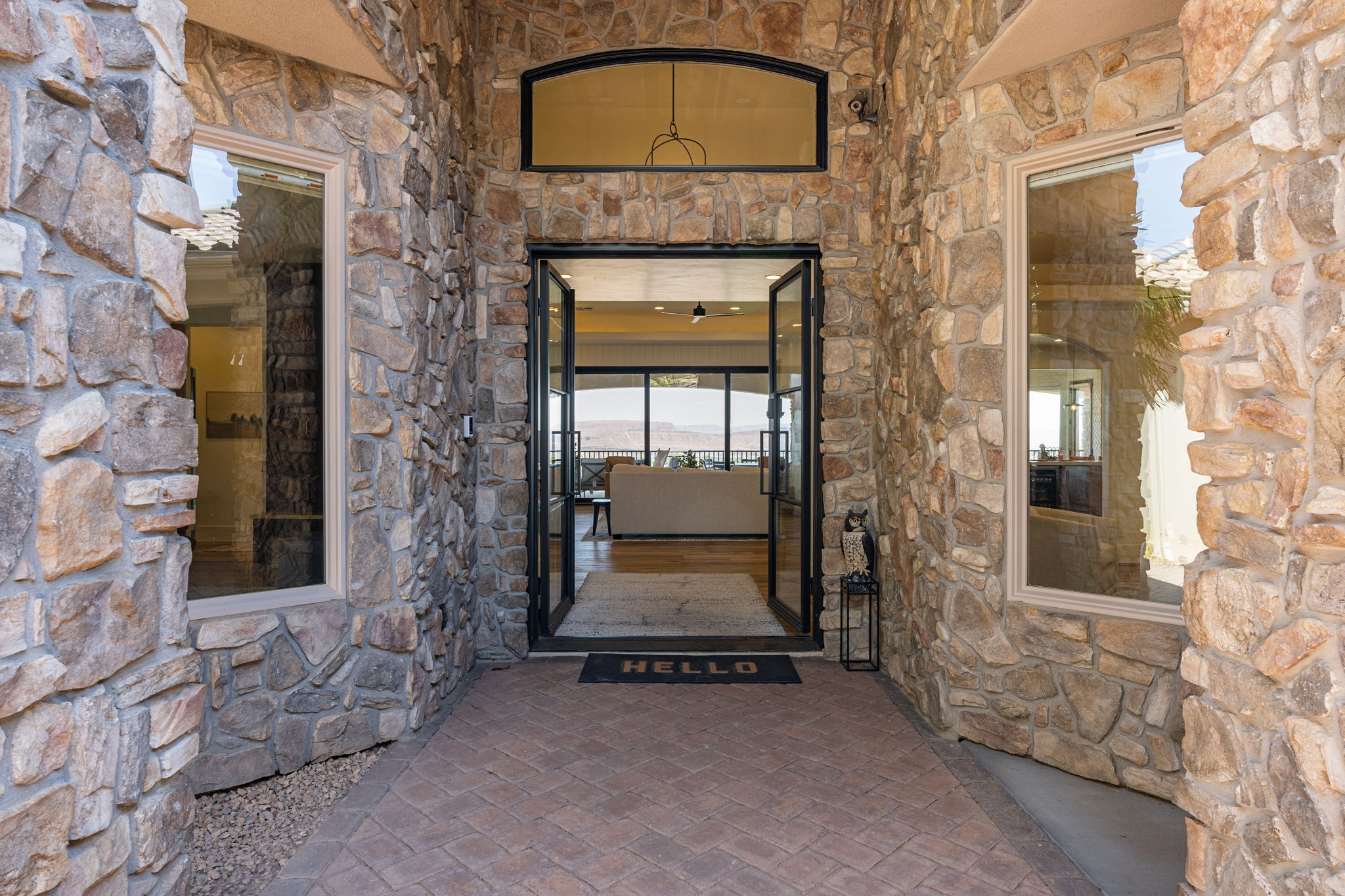Stone facade entry with a paver walkway and double glass doors