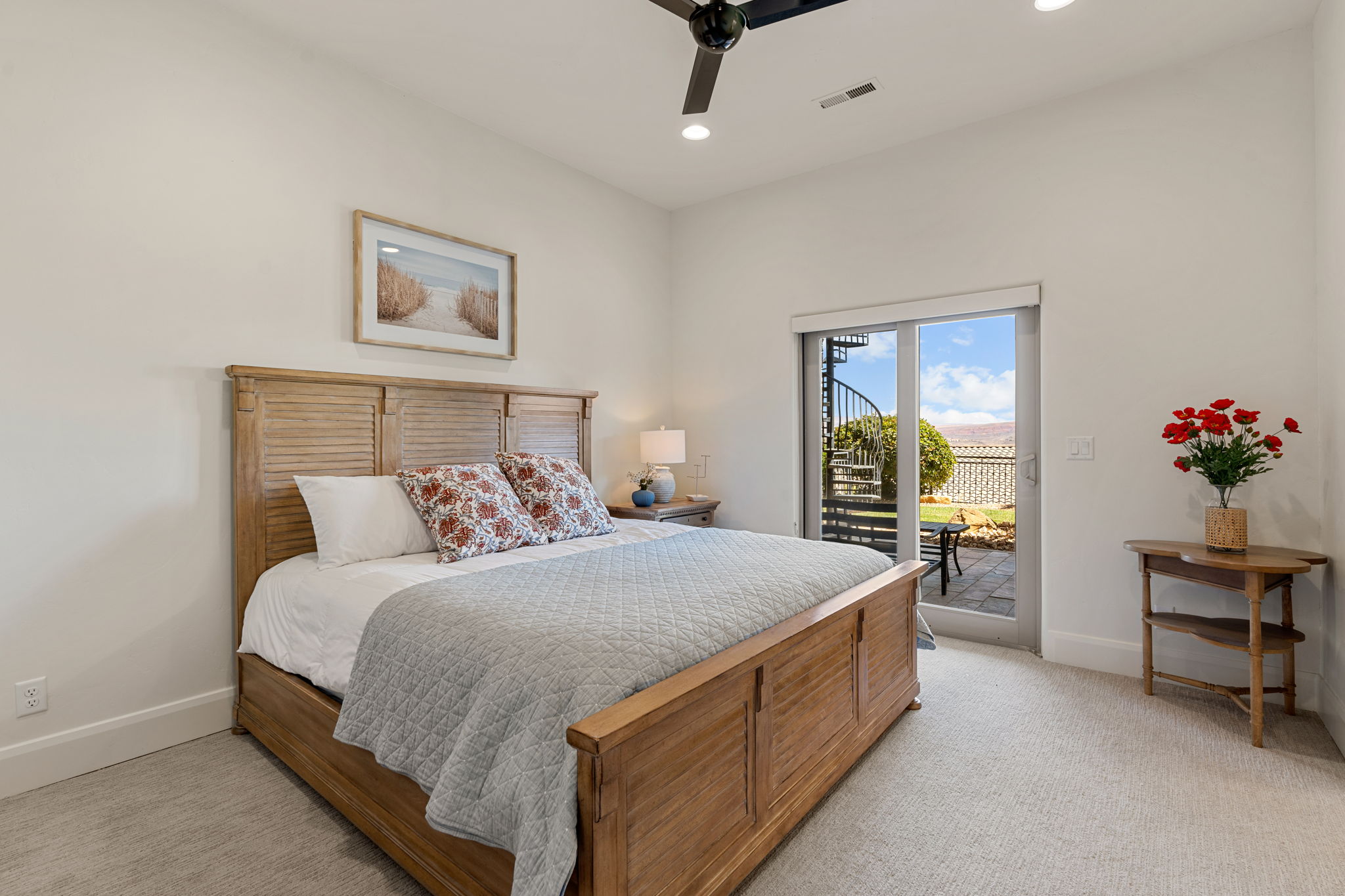 Carpeted bedroom featuring a ceiling fan with integrated lighting