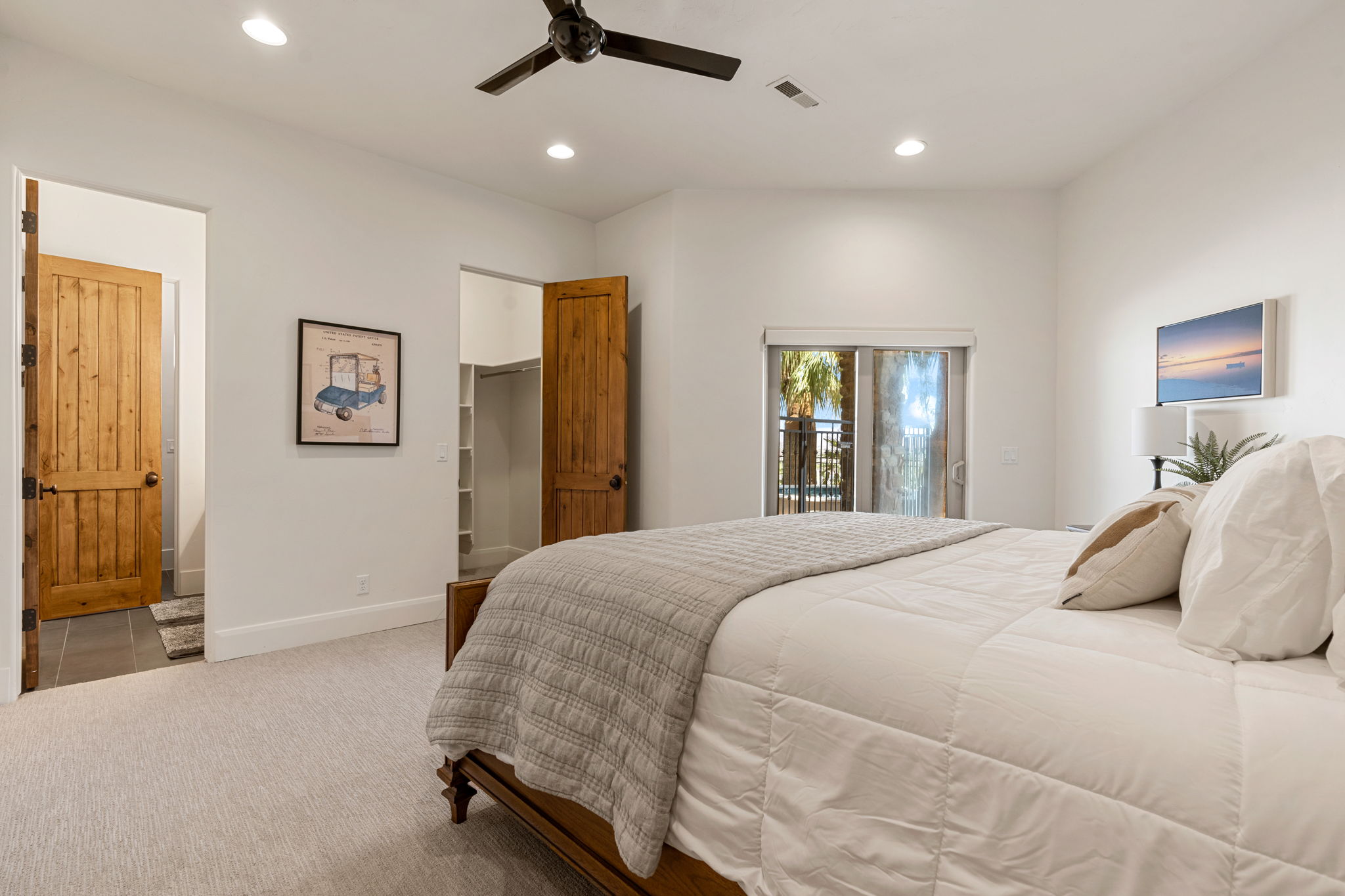 Carpeted room featuring a built-in ceiling fan with light, recessed lighting, and a sliding glass door leading to a balcony