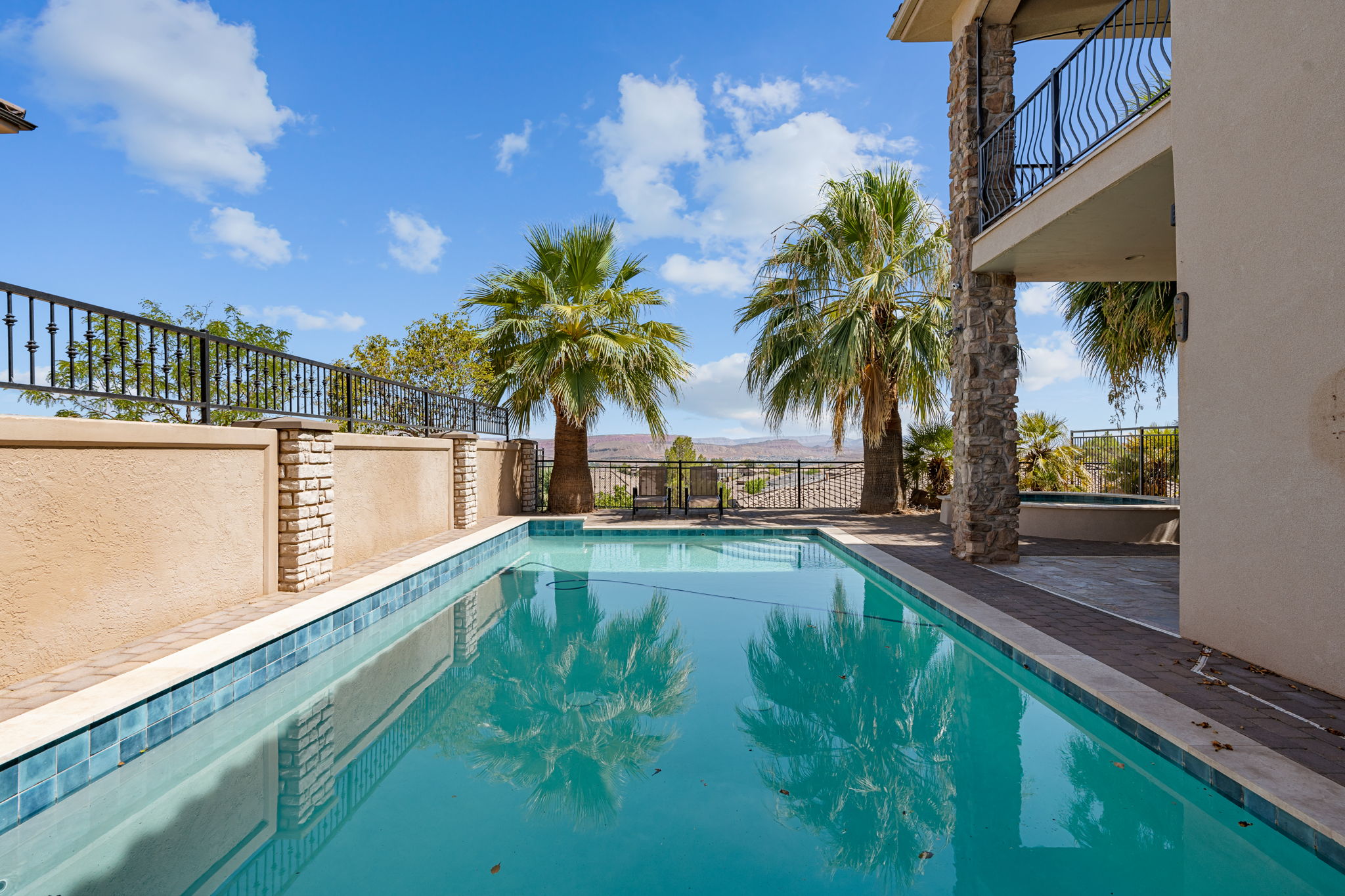 Outdoor swimming pool with a tiled waterline and surrounding hardscaping