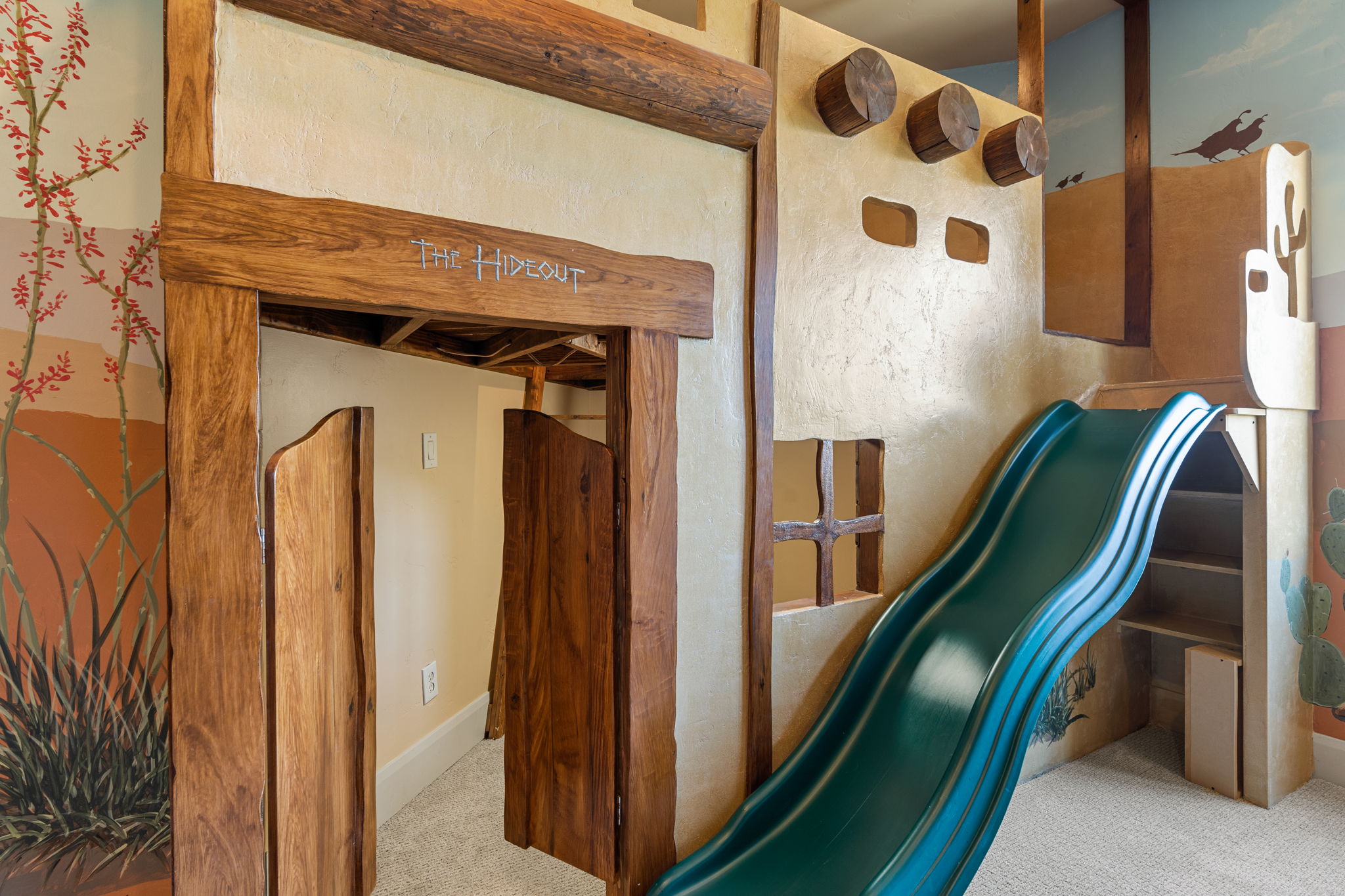 Custom architectural play structure featuring wood-finish beams and a southwestern-inspired facade