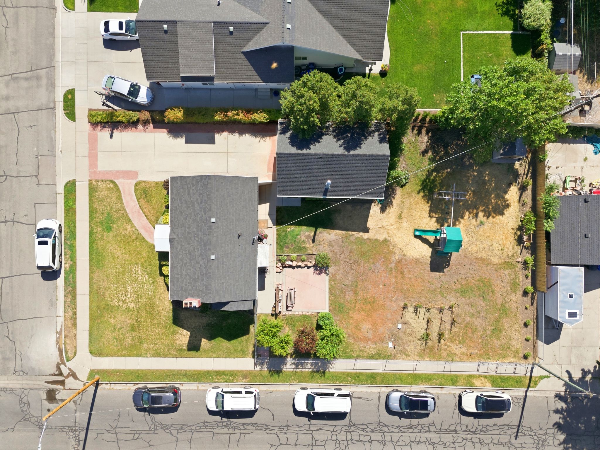 Aerial view of a residential property featuring a gray shingle roof and a paved driveway
