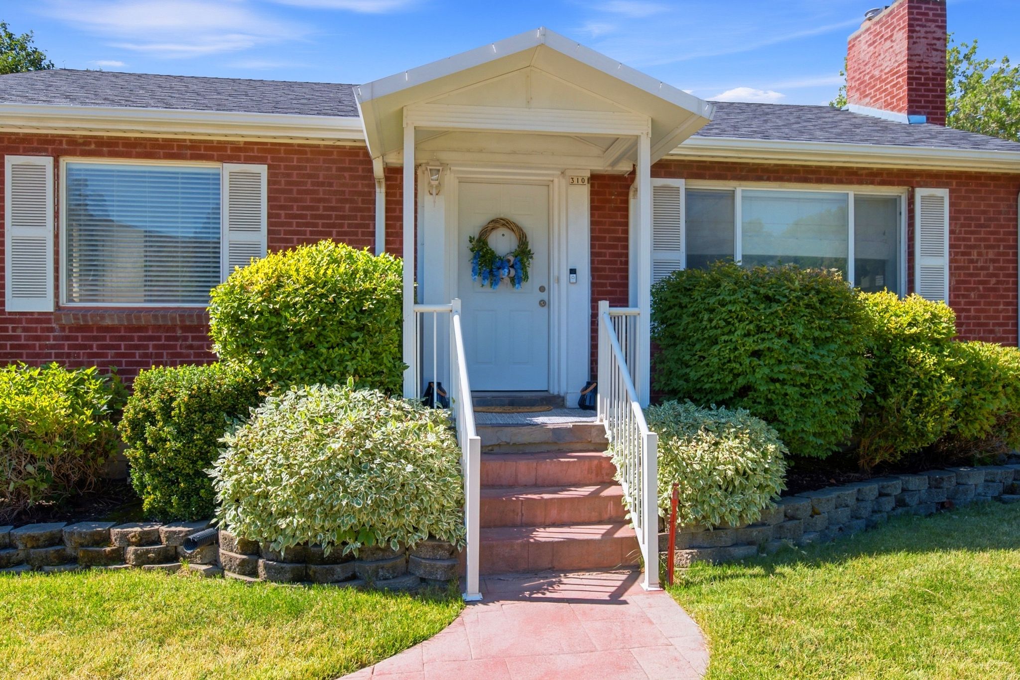 Brick exterior featuring a covered front porch with white railings