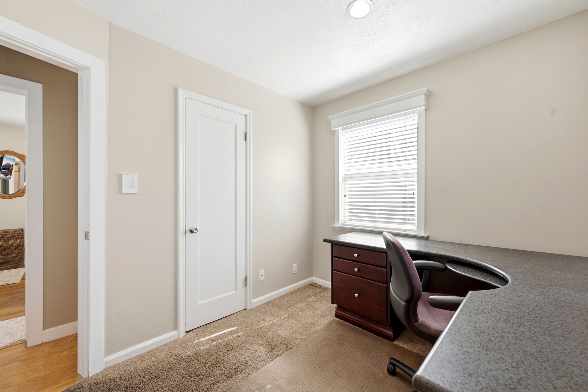 Neutral tone walls complement the carpeted flooring