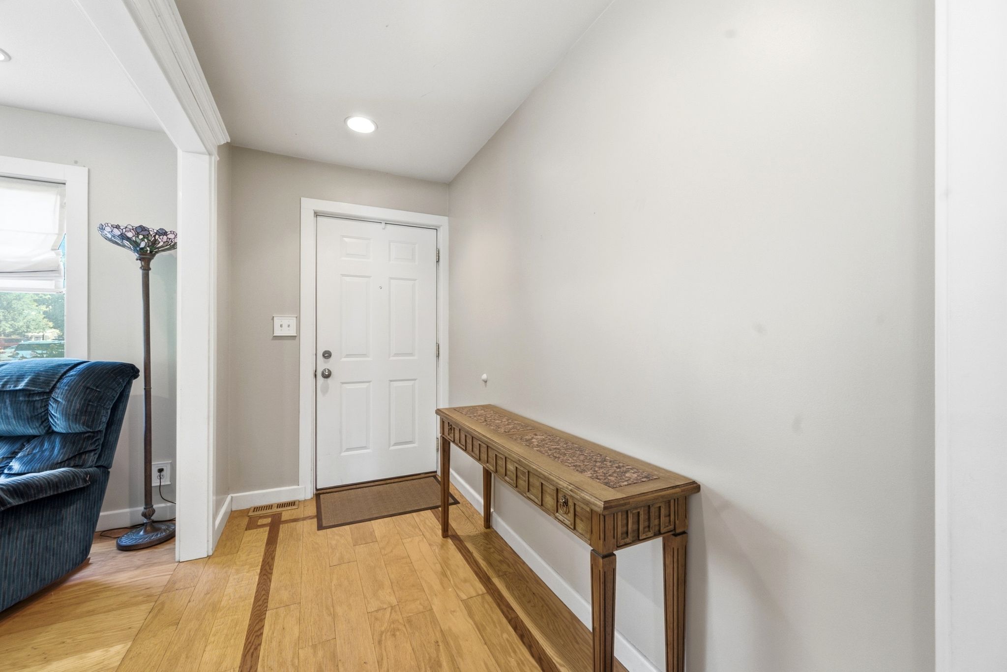 Entryway featuring light-toned walls and wood-finish flooring with an inlay detail