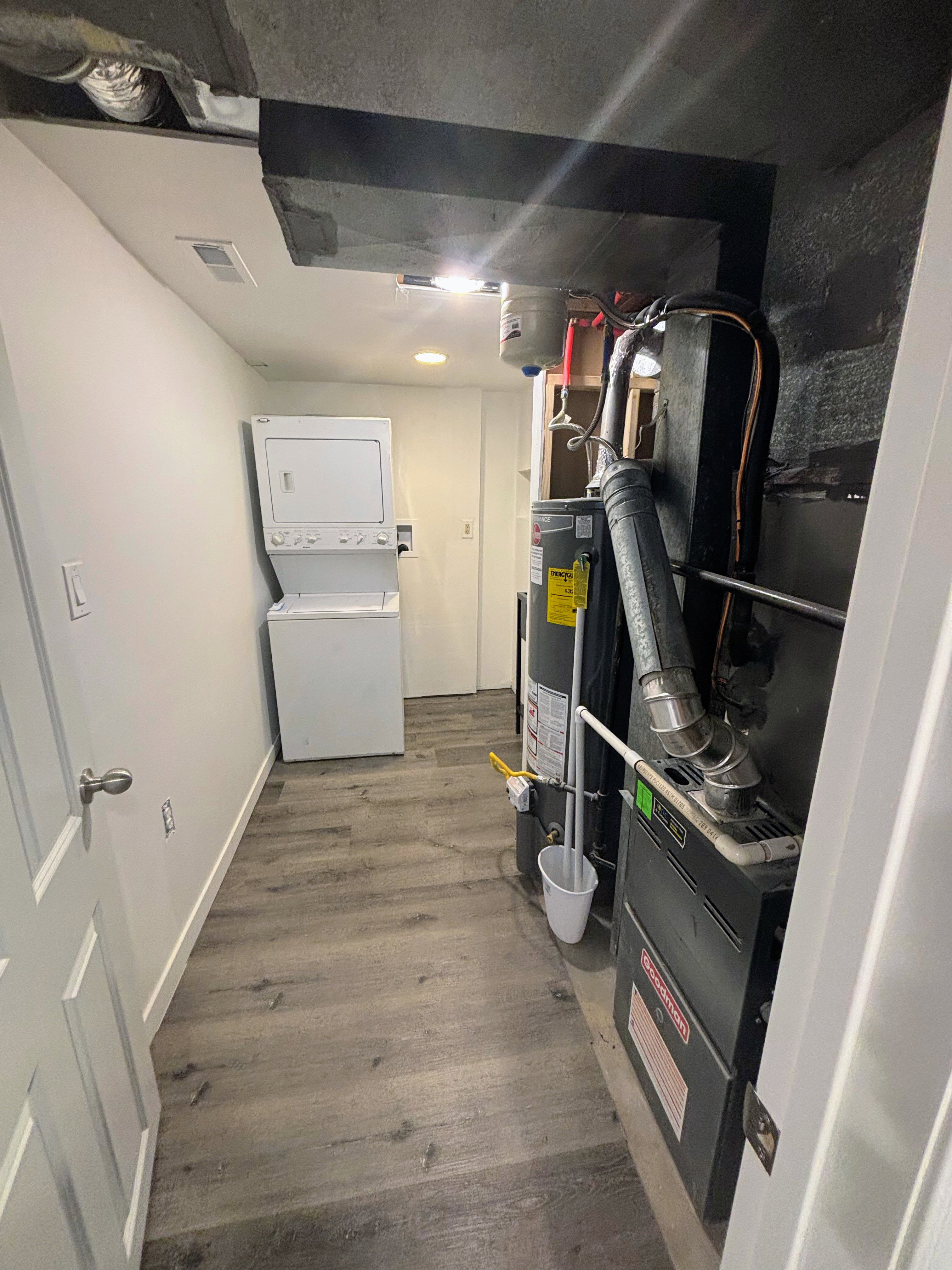 Laundry area with wood-finish flooring and white baseboards.
