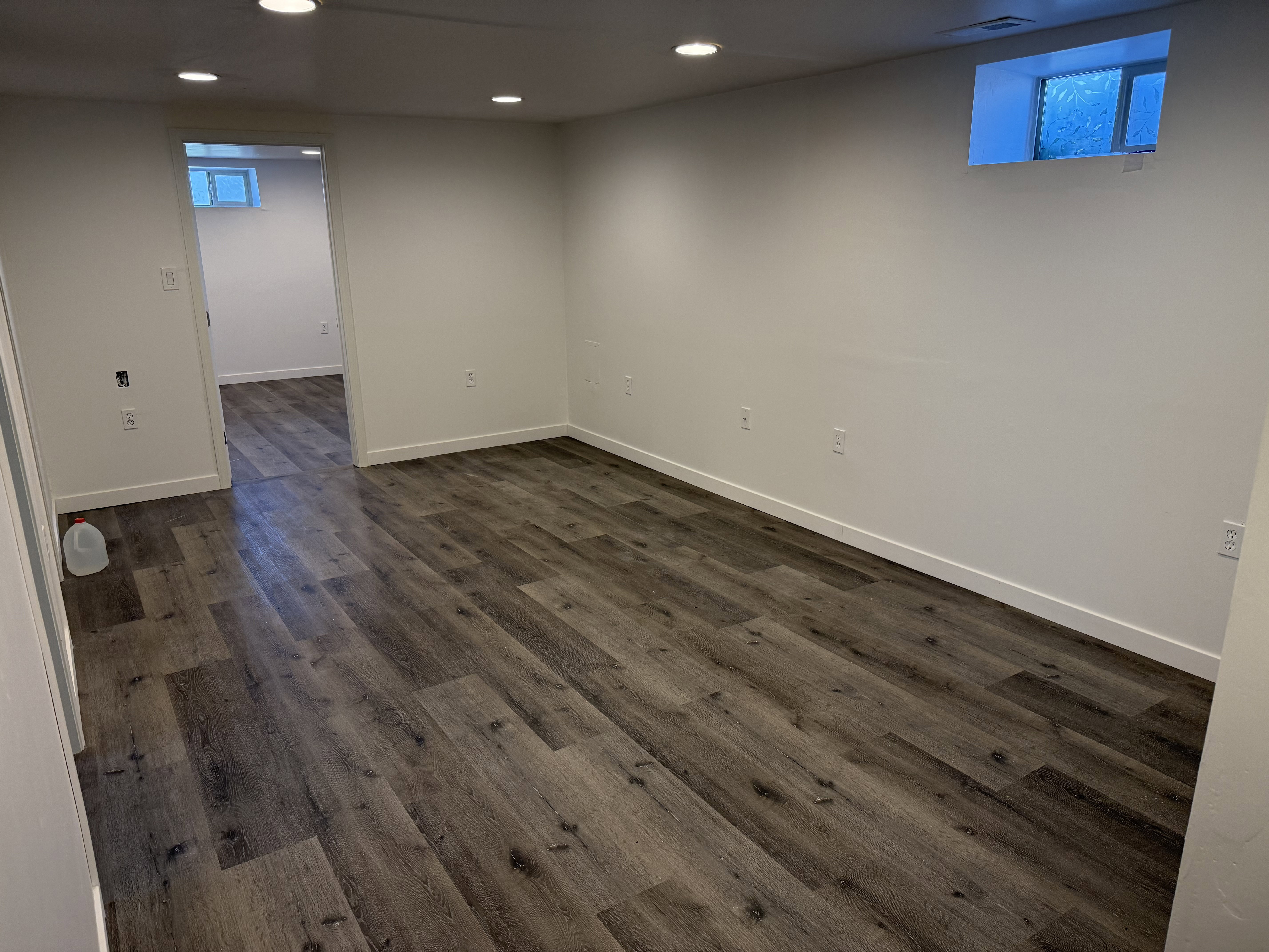 Open concept room featuring wood-finish flooring, recessed lighting, and white baseboards.