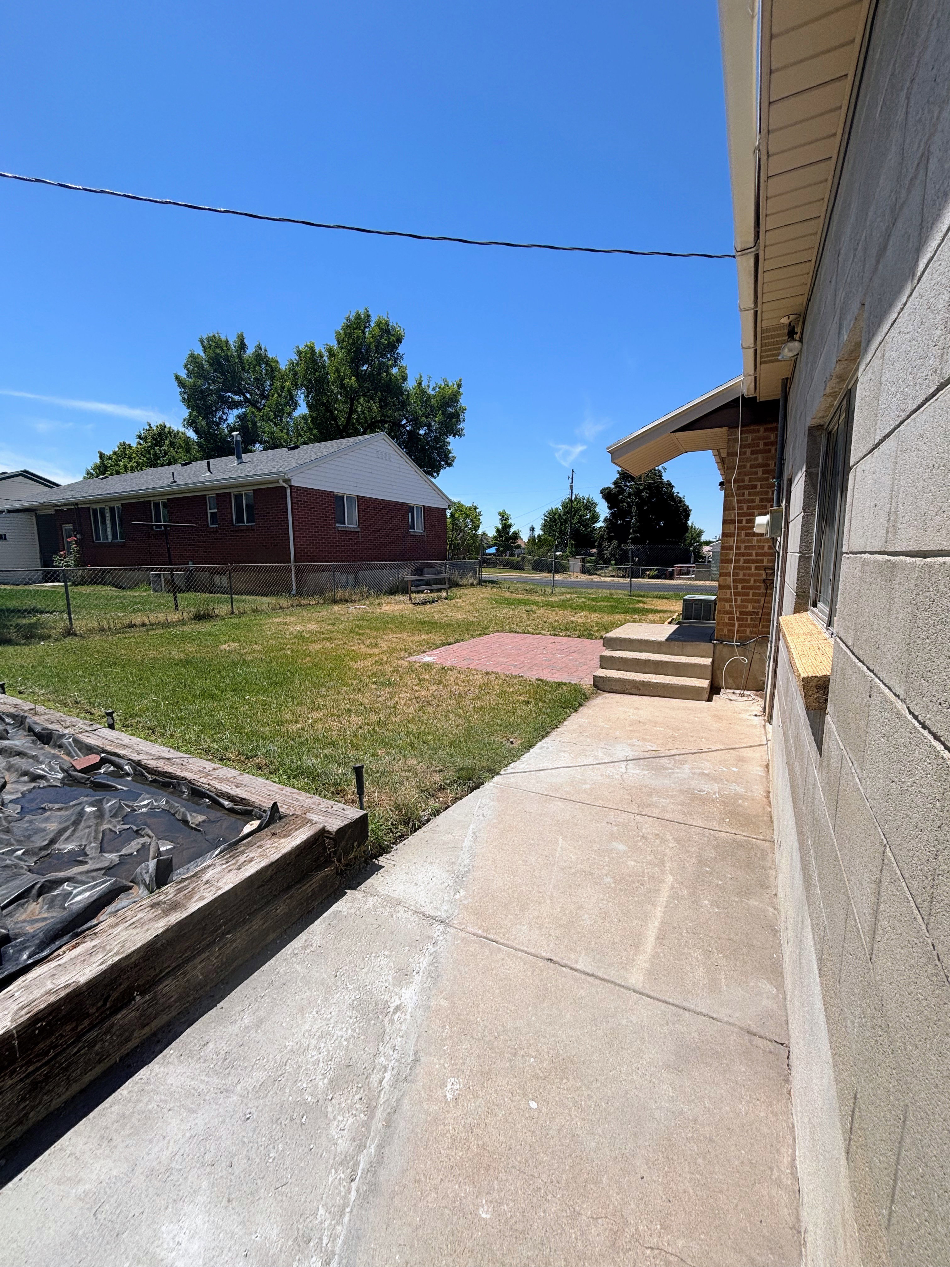 Backyard - Concrete block exterior with a concrete walkway.