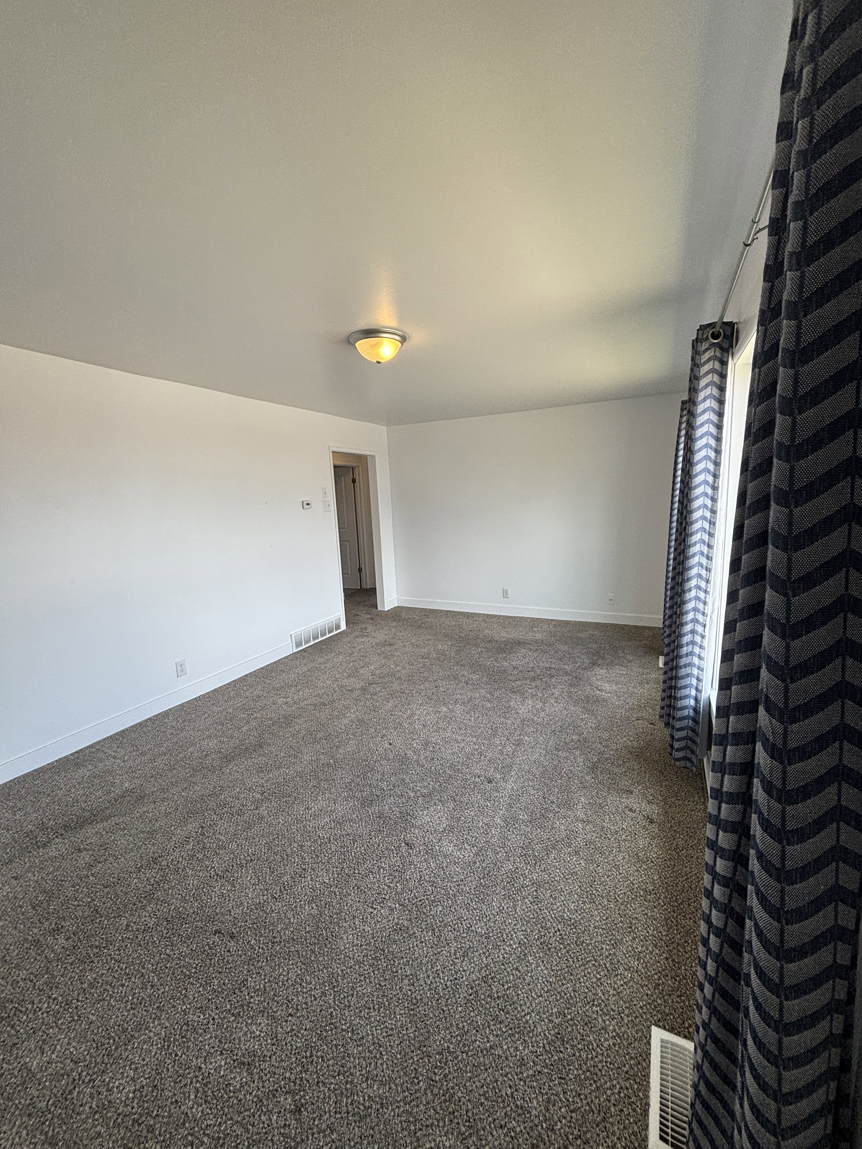 Neutral-toned wall-to-wall carpeting throughout/
