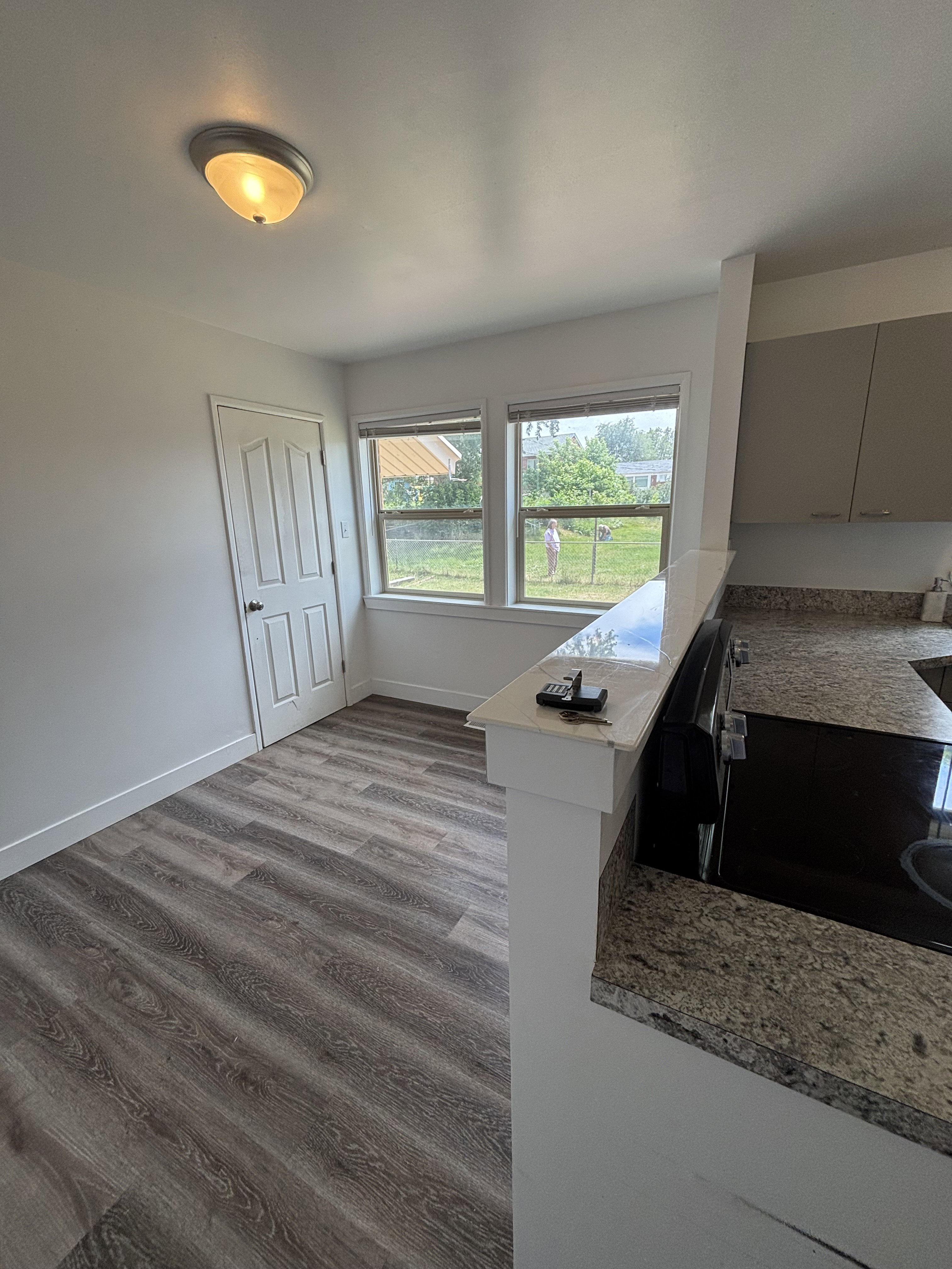 Kitchen area featuring wood-finish flooring, a breakfast bar with a light granite-style countertop, and the stove/countertop.